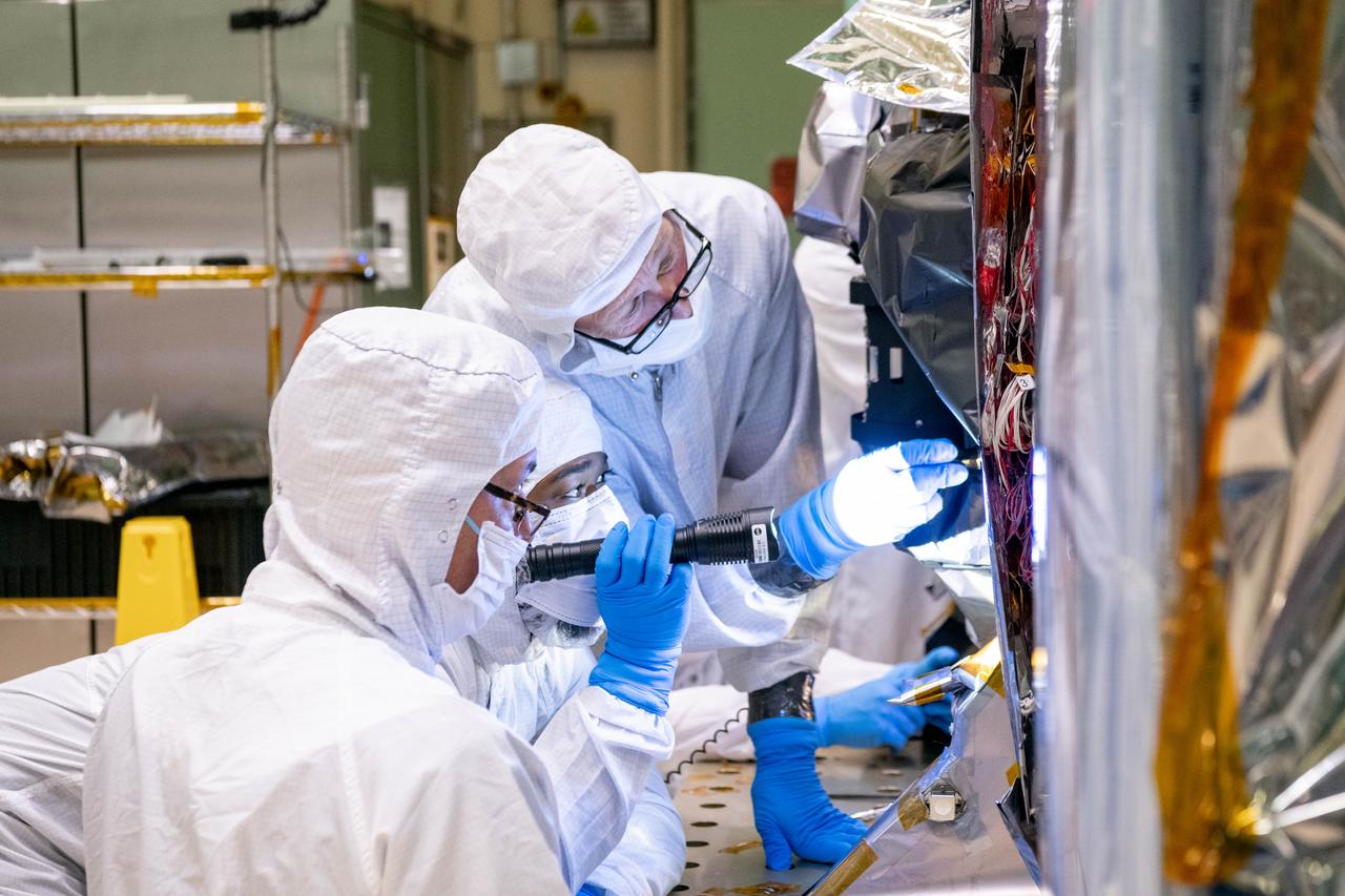 Mechanical technicians, Nicholas Kwaitkowski, Tyere Garner, and Gary Sheridon, use a flashlight to check for clearances between the Tilt Mechanism and the Ocean Color Instrument (OCI). OCI is a highly advanced optical spectrometer that will be used to measure properties of light over portions of the electromagnetic spectrum. It will enable continuous measurement of light at finer wavelength resolution than previous NASA satellite sensors, extending key system ocean color data records for climate studies. OCI is PACE's (Plankton, Aerosol, Cloud, ocean Ecosystem) primary sensor built at Goddard Space Flight Center in Greenbelt, MD.