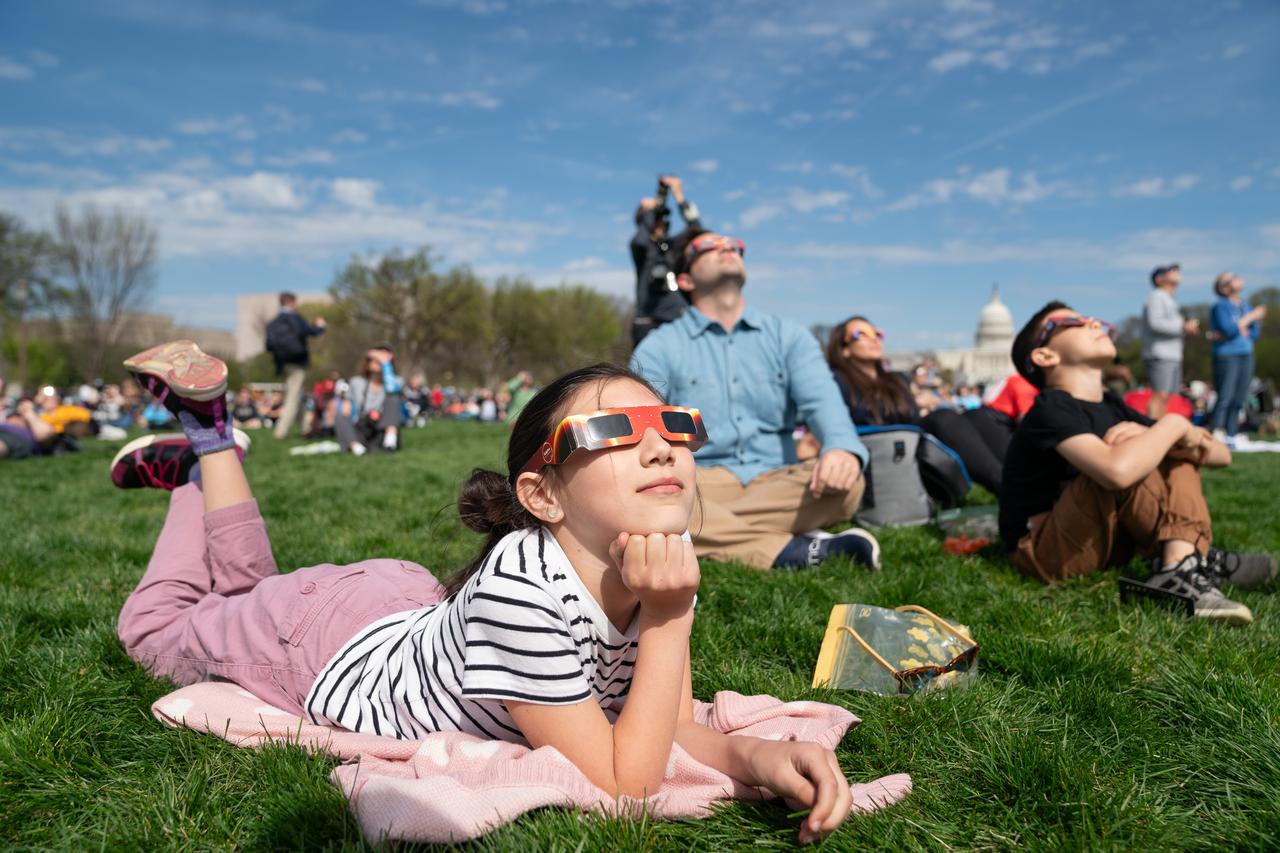 Miranda Dyal (9) views a partial solar eclipse in Washington, DC, Monday, April 8, 2024. A total solar eclipse swept across a narrow portion of the North American continent from Mexico’s Pacific coast to the Atlantic coast of Newfoundland, Canada. A partial solar eclipse was visible across the entire North American continent along with parts of Central America and Europe. Photo Credit: (NASA/Denny Henry)