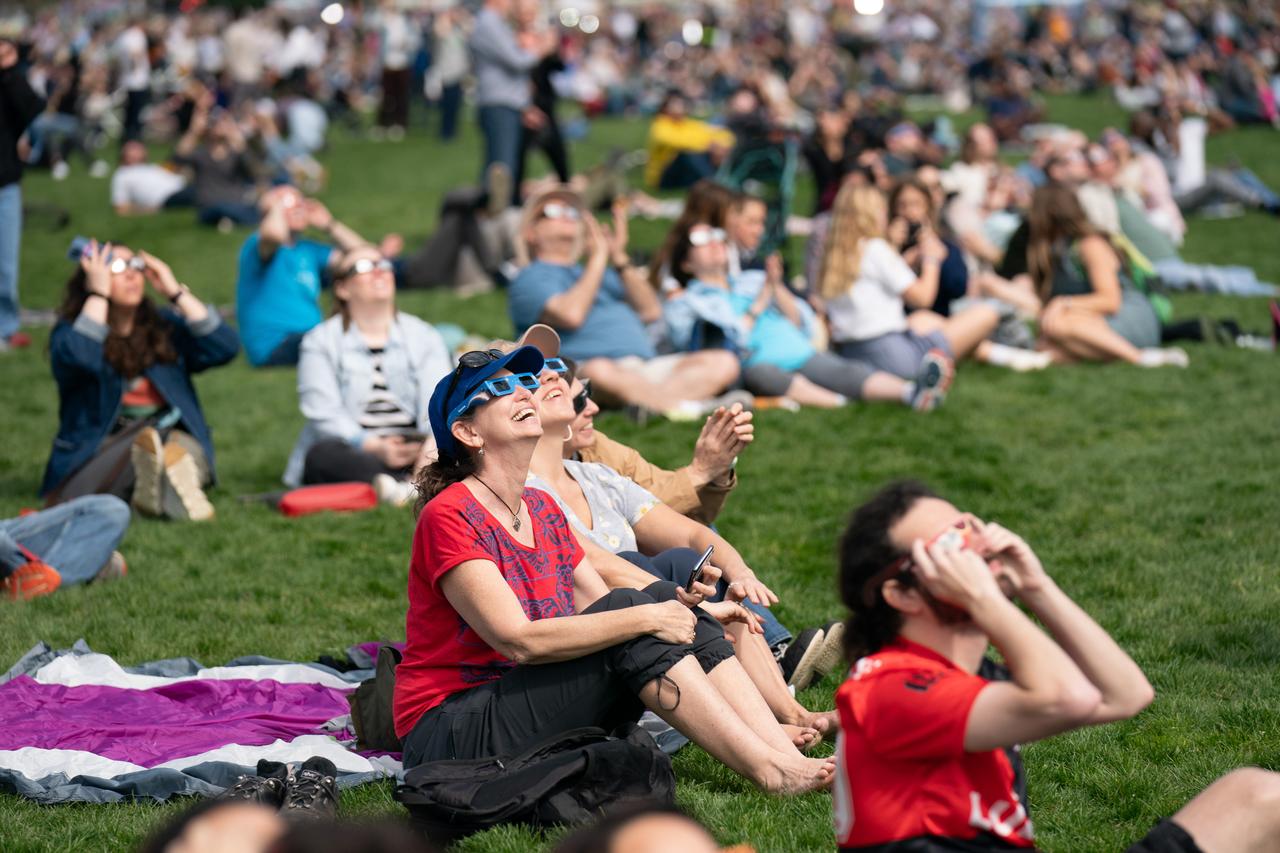 Spectators on the National Mall during a partial solar eclipse in Washington, DC, Monday, April 8, 2024. A total solar eclipse swept across a narrow portion of the North American continent from Mexico’s Pacific coast to the Atlantic coast of Newfoundland, Canada. A partial solar eclipse was visible across the entire North American continent along with parts of Central America and Europe. Photo Credit: (NASA/Denny Henry)