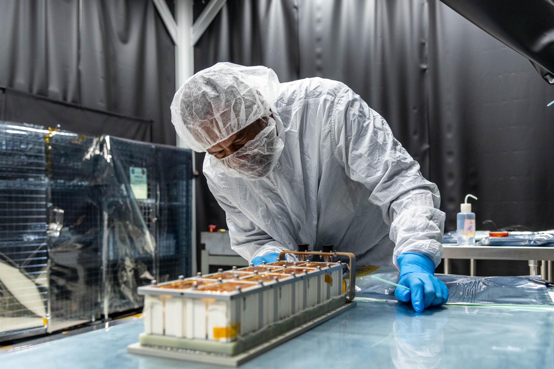 Contamination Control Technician, Rudy Foxwell, inspects the Lunar Environment Monitoring Station (LEMS) Flight Battery in a clean tent at NASA's Goddard Space Flight Center in Greenbelt, Maryland on October 14th, 2026. NASA/Katie Mellos.