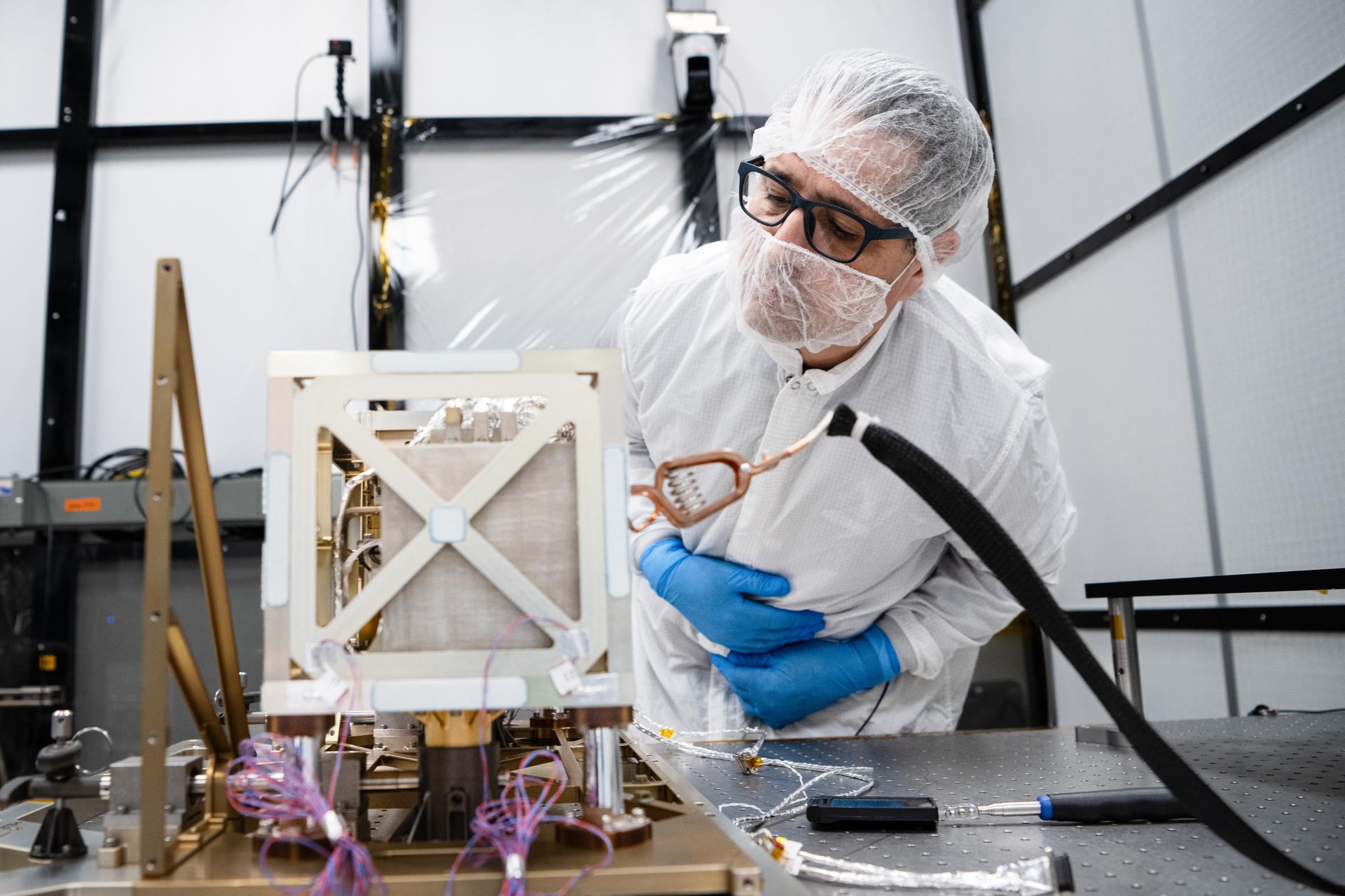 Principal Investigator Dr. Mehdi Benna inspects the Lunar Environment Monitoring Station (LEMS) instrument in the cleanroom at Goddard Space Flight Center in Greenbelt Md. on January 9th, 2026. LEMS is a compact, autonomous, and self-sustaining seismometer suite designed to carry out continuous, long-term, monitoring of the lunar seismic environment at the South Polar region. Photo Credit: NASA/Denny Henry 