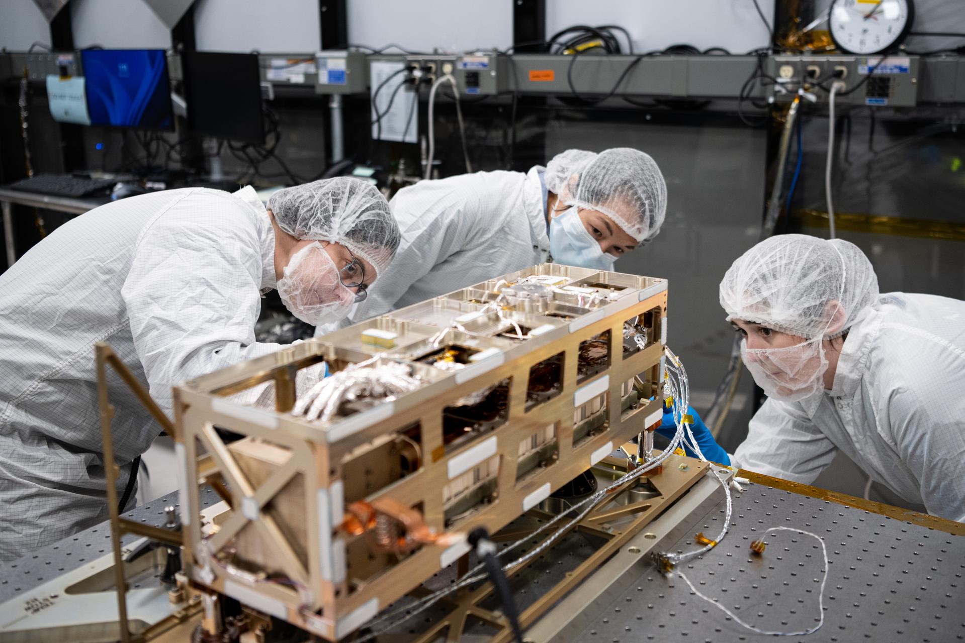 (L-R) Contamination Control Engineer Diane Briczinski, Acting Science Mission Directorate Chief Engineer Synthia Tonn, and Lead Payload Systems Engineer Sam Hicks inspect the Lunar Environment Monitoring Station (LEMS) instrument in the cleanroom at Goddard Space Flight Center in Greenbelt Md. on January 12th, 2026. LEMS is a compact, autonomous, and self-sustaining seismometer suite designed to carry out continuous, long-term, monitoring of the lunar seismic environment at the South Polar region. Photo Credit: NASA/Denny Henry 