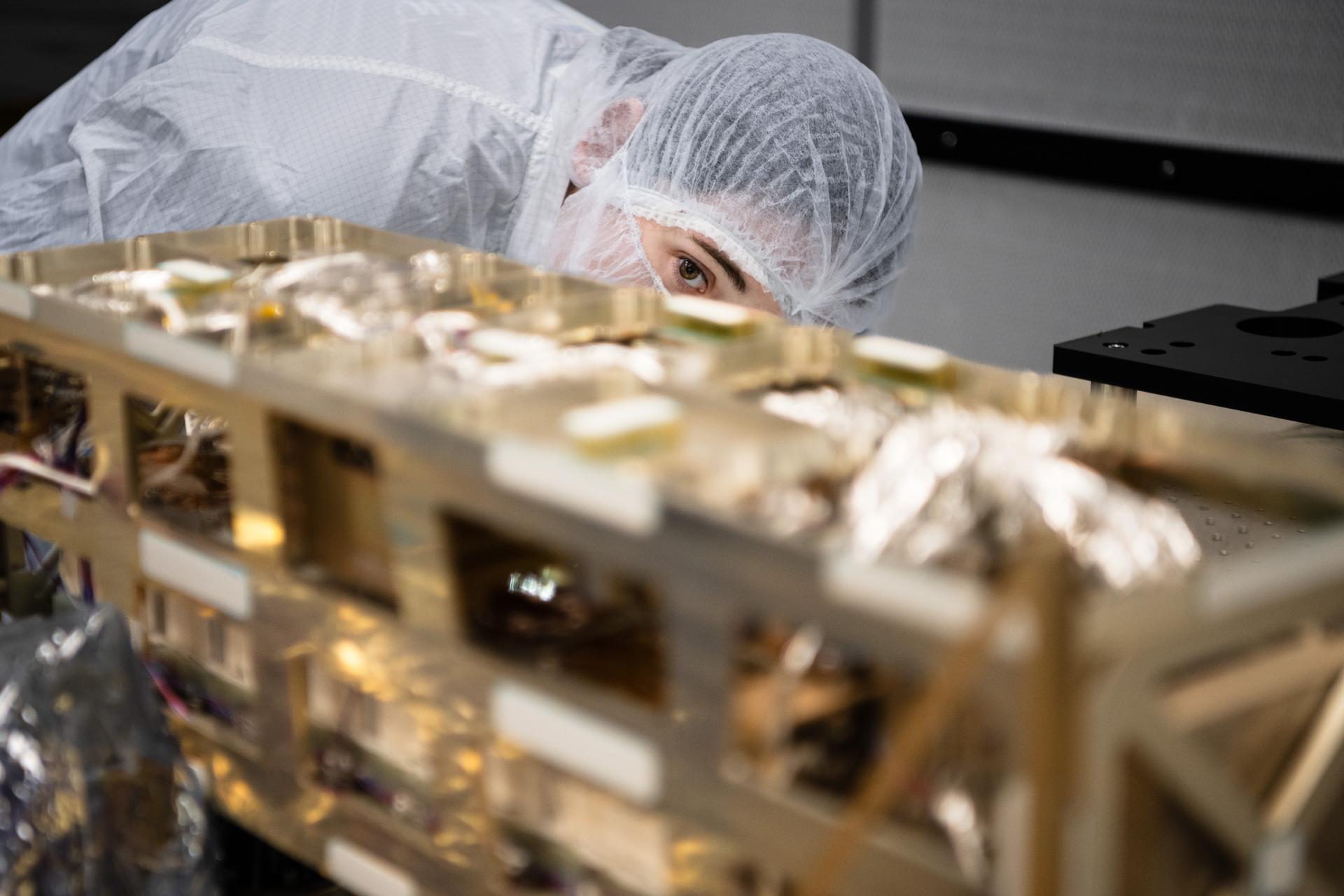 Lead Payload Systems Engineer Sam Hicks  inspects the Lunar Environment Monitoring Station (LEMS) instrument in the cleanroom at Goddard Space Flight Center in Greenbelt Md. on January 12th, 2026. LEMS is a compact, autonomous, and self-sustaining seismometer suite designed to carry out continuous, long-term, monitoring of the lunar seismic environment at the South Polar region. Photo Credit: NASA/Denny Henry 