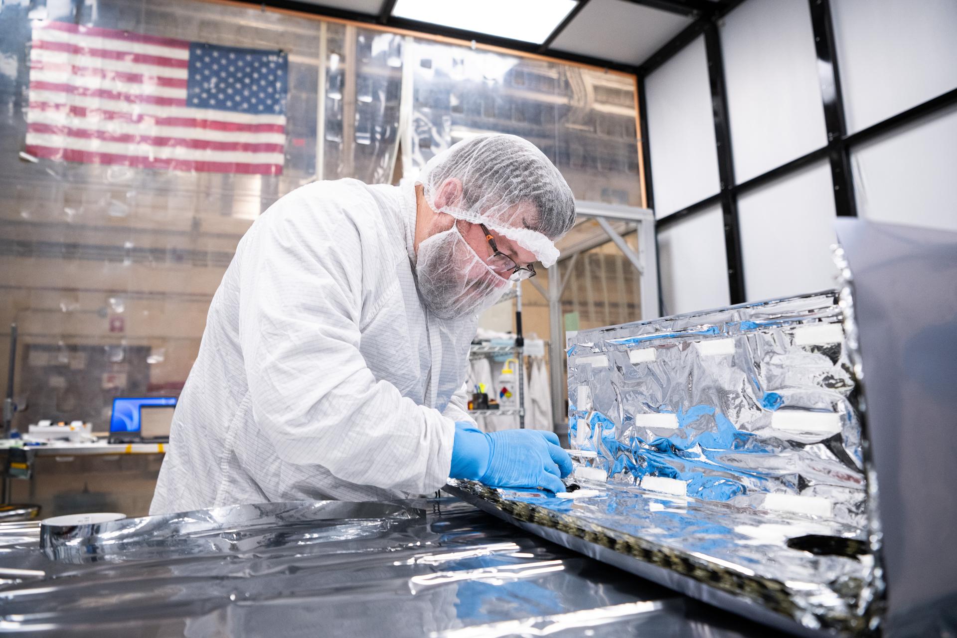 Chief Operating Officer of Quest Thermal Group Phillip Tyler installs Integrated Multilayer Insulation (IMLI) on the Lunar Environment Monitoring Station for Artemis (LEMS) bus inside a cleanroom at Goddard Space Flight Center, Greenbelt Md., Jan 13, 2026. LEMS is a compact, autonomous, and self-sustaining seismometer suite designed to carry out continuous, long-term, monitoring of the lunar seismic environment at the South Polar region. Photo Credit: NASA/Denny Henry