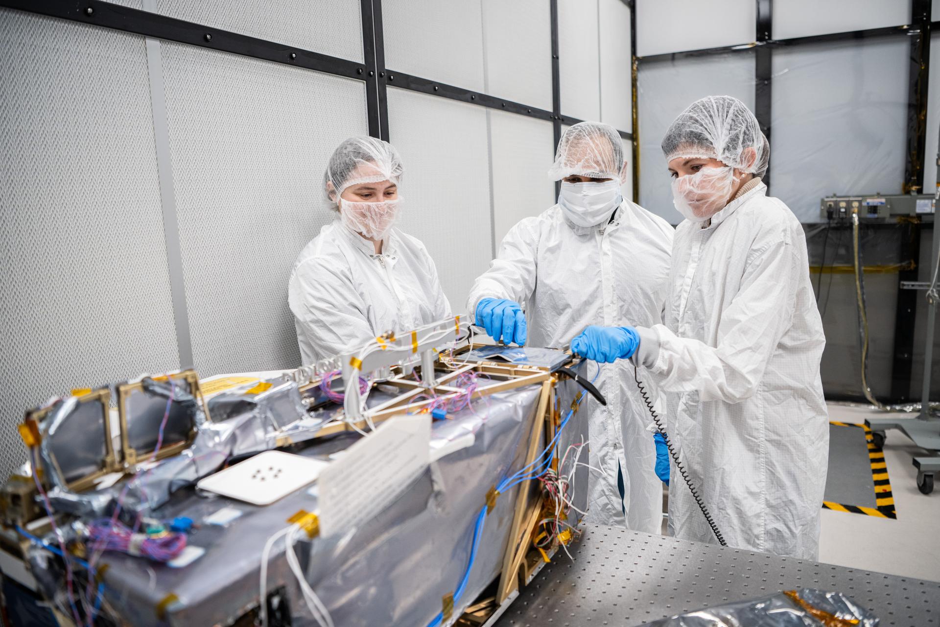 (L-R) Mechanical Engineer Brie Ludwig, Project Manager Neerav Shah and Deputy Project Manager Stephanie Vidal inspect the Lunar Environment Monitoring Station (LEMS) instrument in the cleanroom at Goddard Space Flight Center in Greenbelt Md. on February 5th, 2026. LEMS is a compact, autonomous, and self-sustaining seismometer suite designed to carry out continuous, long-term, monitoring of the lunar seismic environment at the South Polar region. Photo Credit: NASA/Denny Henry 