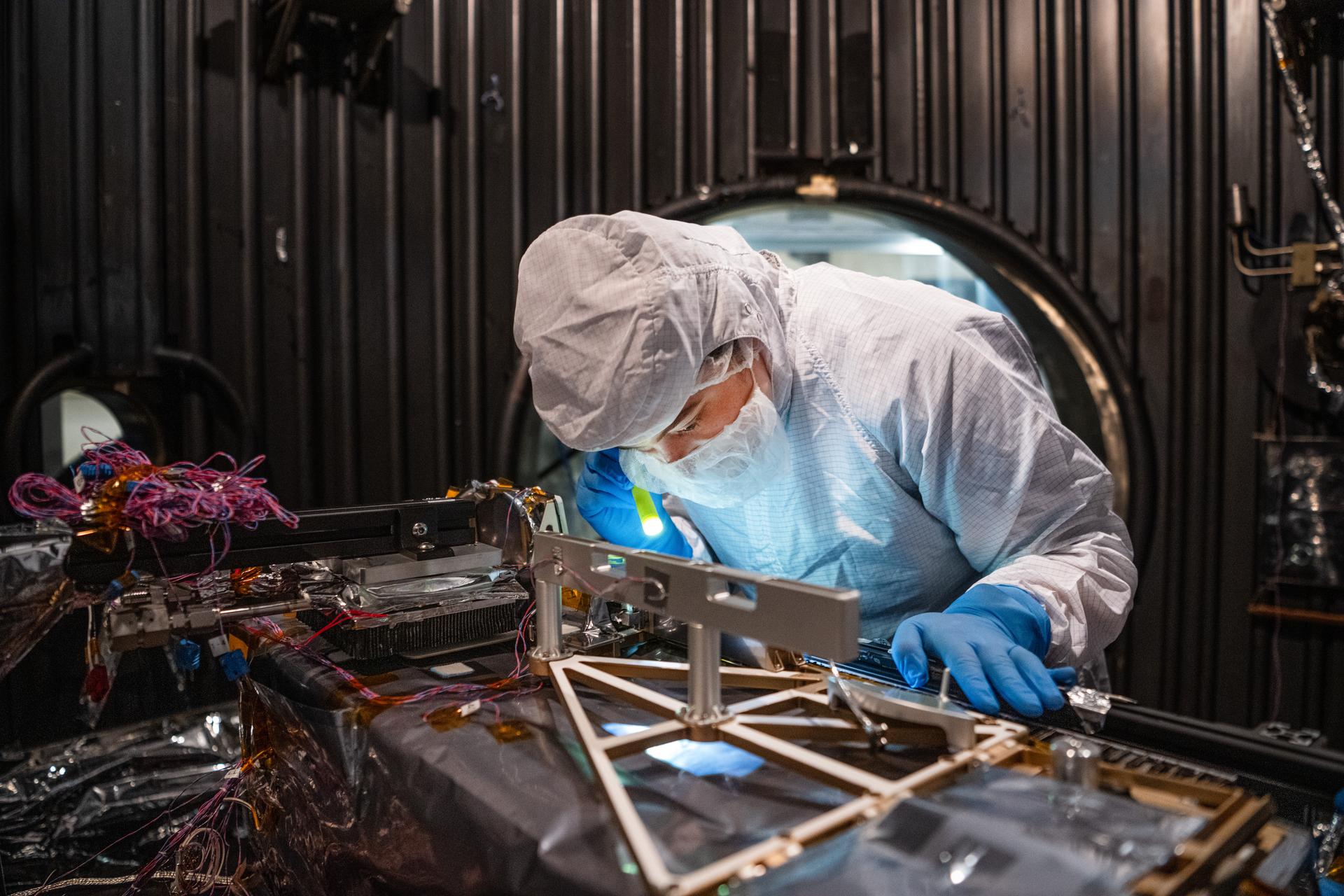 Mechanical Engineer Brie Ludwig inspects the Lunar Environment Monitoring Station (LEMS) instrument in preparation for testing in a thermal vacuum chamber at Goddard Space Flight Center in Greenbelt Md. on March 31, 2026. LEMS is a compact, autonomous, and self-sustaining seismometer suite designed to carry out continuous, long-term, monitoring of the lunar seismic environment at the South Polar region. Photo Credit: NASA/Denny Henry