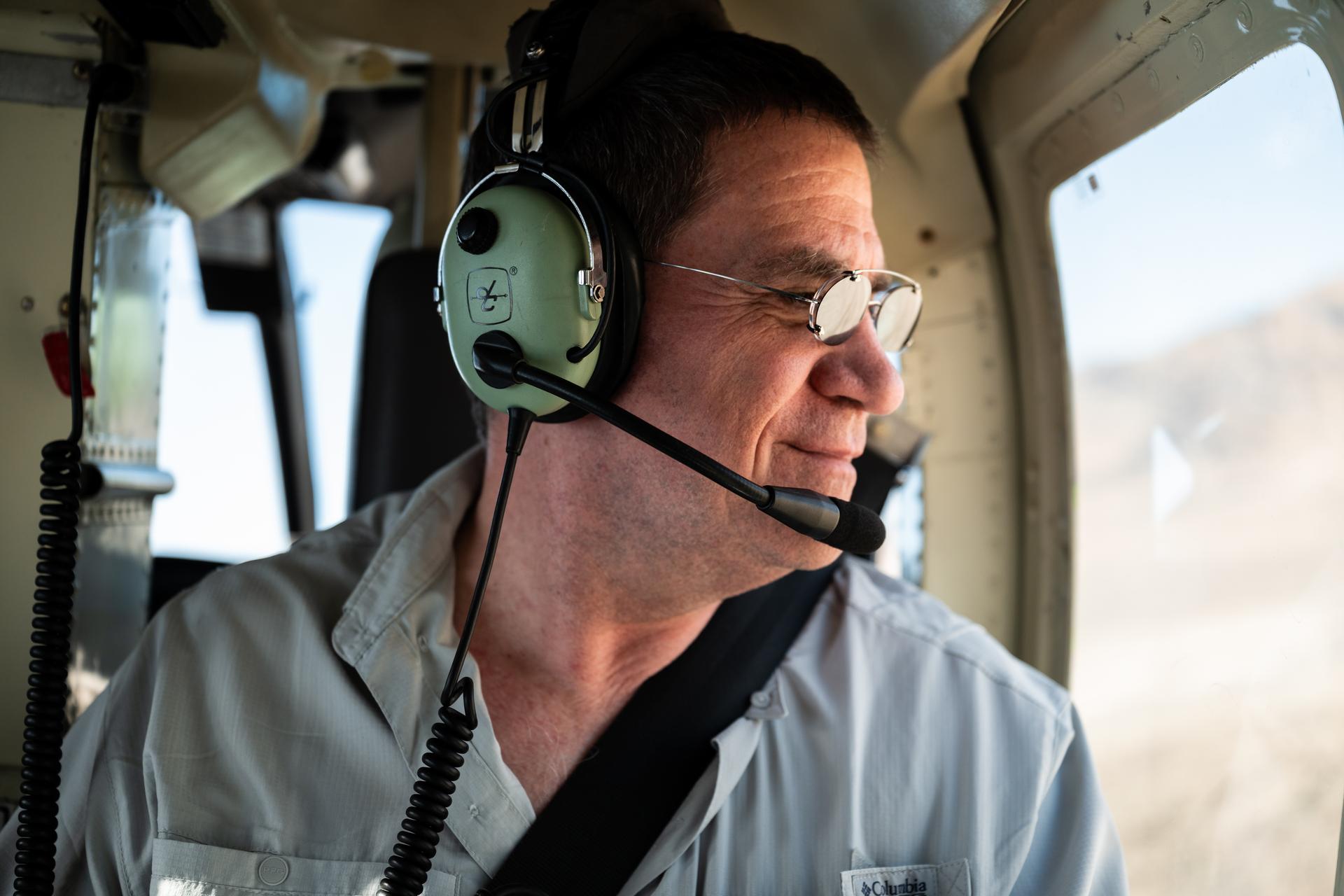 Mike Ravine observes out the helicopter window while in flight over Crater Island, Utah as part of the DAVINCI VADIX experiment, June 23, 2026. NASA/Mike Guinto