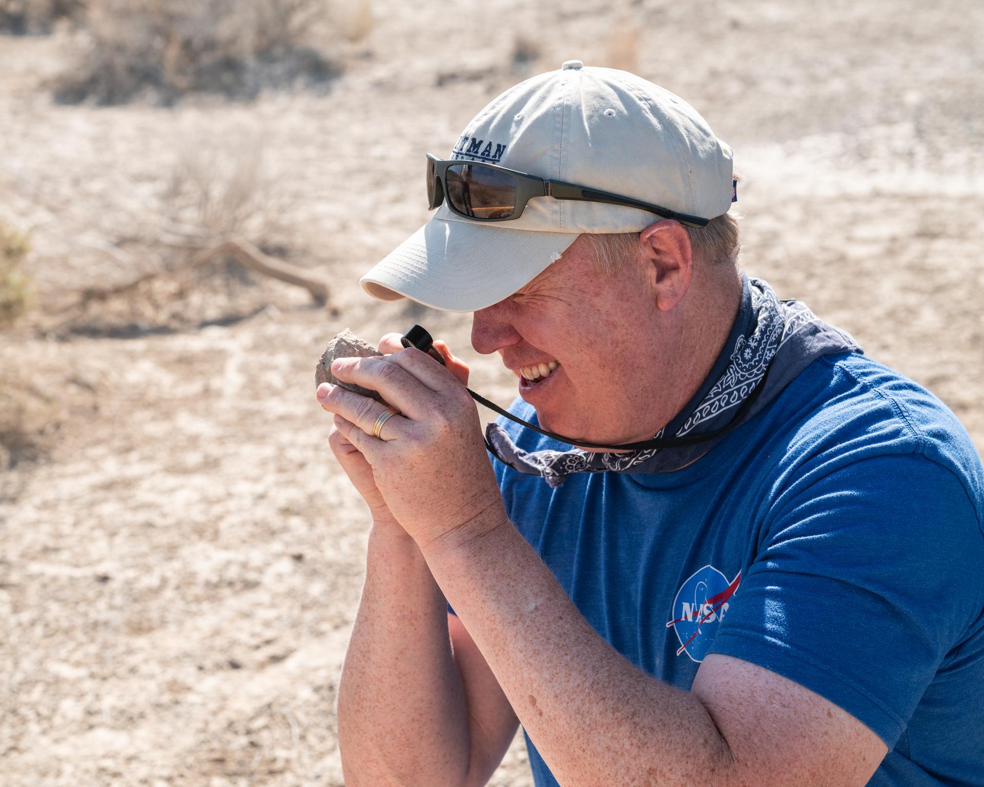 Nick Lang, DAVINCI Science Program Manager at Headquarters NASA, inspects a rock found at Crater Island, Utah during the DAVINCI VADIX experiment, June 23, 2026. NASA/Mike Guinto