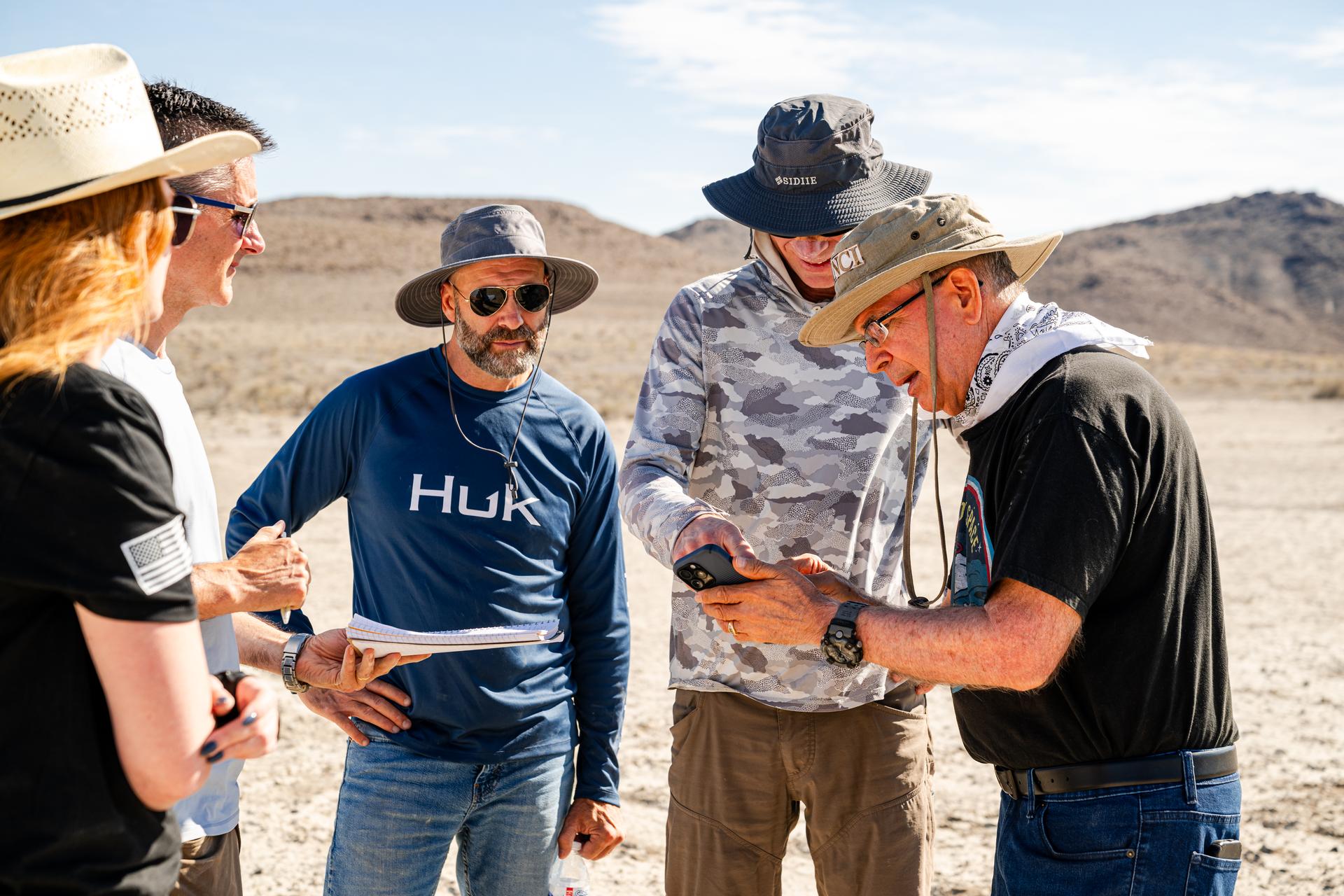 Dr. Jim Garvin, right, discusses flight plans with the pilots in between test flights at Crater Island, Utah, June 24, 2026. NASA/Mike Guinto