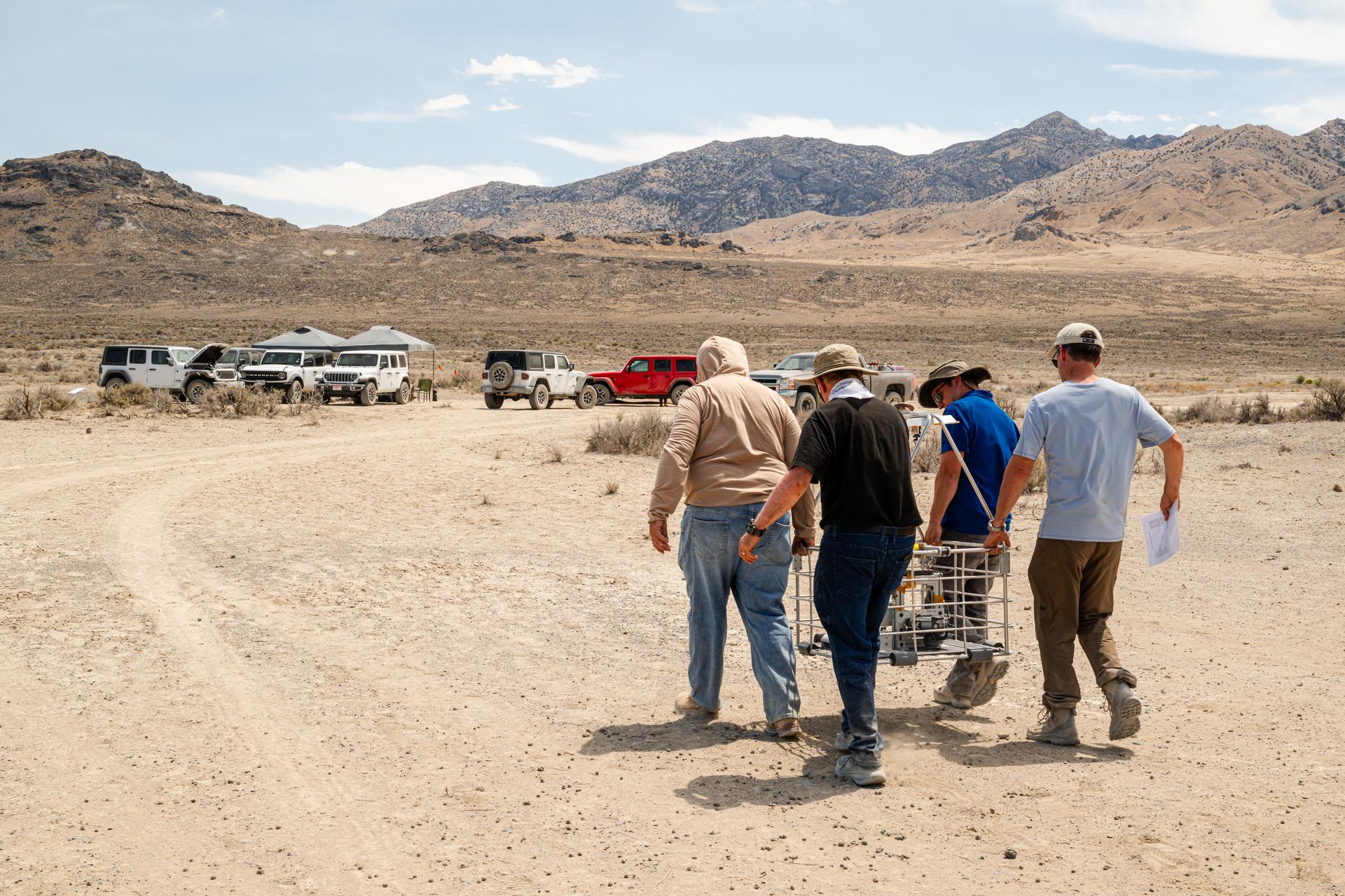 DAVINCI VADIX team carries the VADIX payload from the helicopter back to basecamp so they can retrieve flight data and get the payload back onto the helicopter for the next test flight at Crater Island, Utah, June 24, 2026. NASA/Mike Guinto
