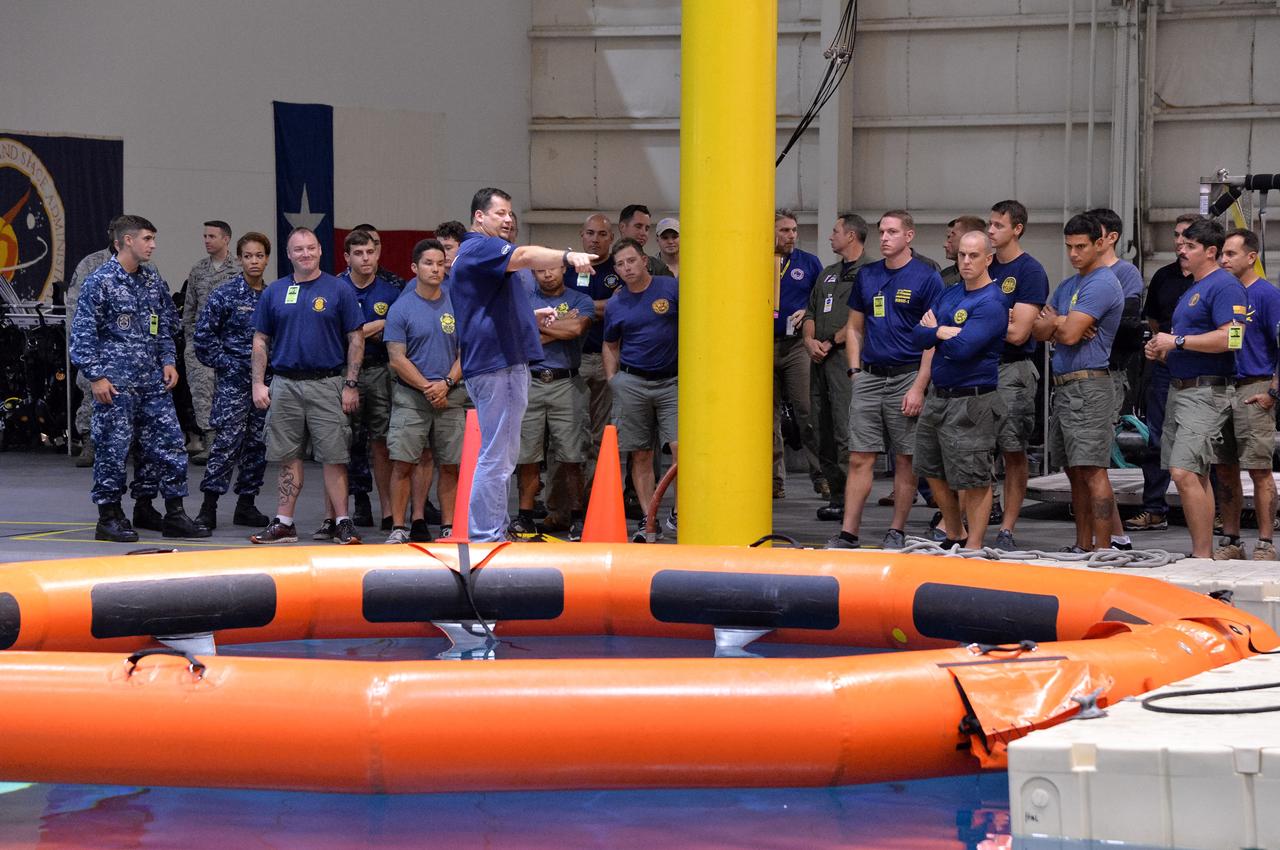 Tim Goddard, NASA Open Water Recovery Operations director, briefs U.S. Navy divers, Air Force pararescuemen and Coast Guard rescue swimmers during training in the Neutral Buoyancy Laboratory at NASA’s Johnson Space Center in Houston. The group is preparing to practice Orion underway recovery techniques using a test version of the Orion spacecraft. Training will help the team prepare for Underway Recovery Test 5 for Exploration Mission 1 aboard the USS San Diego in the Pacific Ocean off the coast of California in October. The Ground Systems Development and Operations Program, along with the U.S. Navy and Lockheed Martin, are preparing the recovery team, hardware and operations to support EM-1 recovery. 