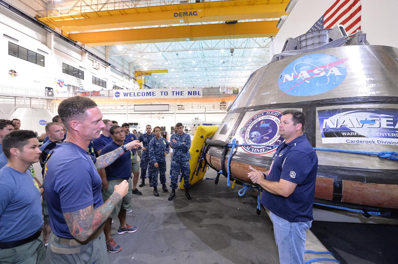 Tim Goddard, far right, NASA Open Water Recovery Operations director, briefs U.S. Navy divers, Air Force pararescuemen and Coast Guard rescue swimmers during training in the Neutral Buoyancy Laboratory at NASA’s Johnson Space Center in Houston. The group is preparing to practice Orion underway recovery techniques using a test version of the Orion spacecraft. Training will help the team prepare for Underway Recovery Test 5 for Exploration Mission 1 aboard the USS San Diego in the Pacific Ocean off the coast of California in October. The Ground Systems Development and Operations Program, along with the U.S. Navy and Lockheed Martin, are preparing the recovery team, hardware and operations to support EM-1 recovery. 