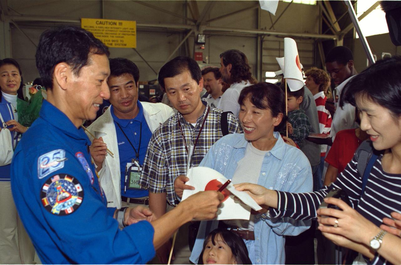 JSC2000-01638 (23 February 2000) ---  Astronaut Mamoru Mohri signs autographs  for some members of the crowd who turned out for the STS-99 crew arrival  at Ellington Field, near the Johnson Space Center (JSC).  After spending their first night back from space in Florida, the six astronauts flew to Houston, where they were greeted by  the crowd of  supporters at Ellington's  Hangar 990.