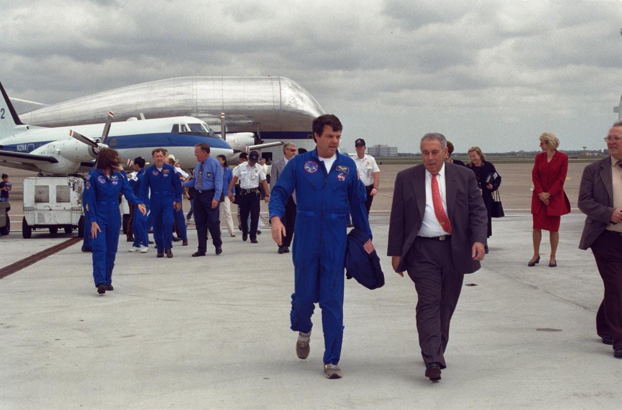 JSC2000-01671 (23 February 2000) ---  Astronaut Kevin R. Kregel (left foreground), mission commander for STS-99, walks with JSC Director George W.S. Abbey toward Ellington Field's Hangar 990 following crew arrival on February 23.  The six-member crew was welcomed by a crowd of supporters in the hangar.