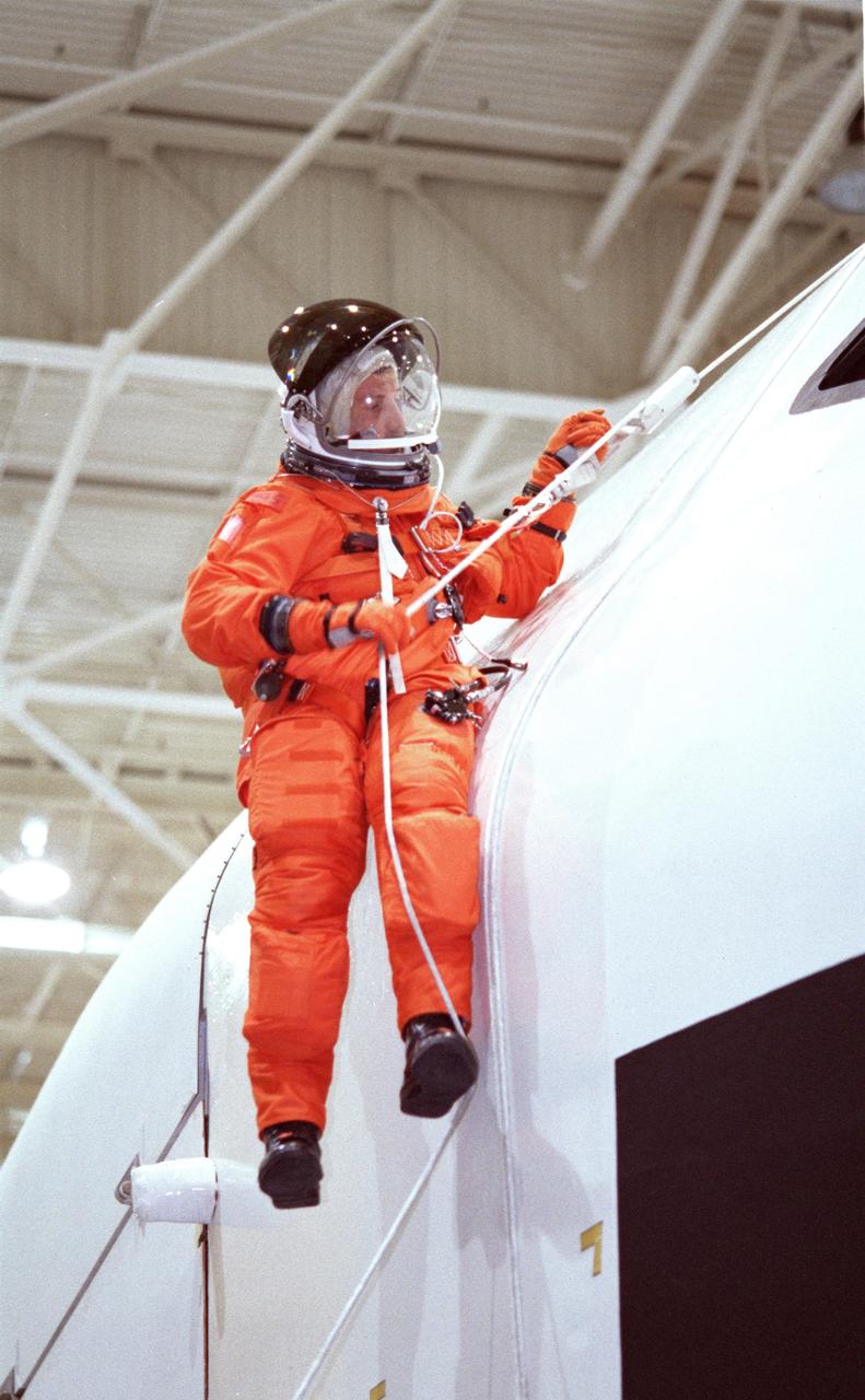 JSC2000-02931 (5 April 2000) --- Astronaut Daniel C. Burbank, STS-106 mission specialist, rappels from the top of a simulated shuttle in trouble (actually a crew training mockup) during emergency egress training at the Johnson Space Center's Systems Integration Facility. Burbank will join  four other NASA astronauts and two cosmonauts representing the Russian Aviation and Space Agency for a visit to  the International Space Station in late summer of this year.