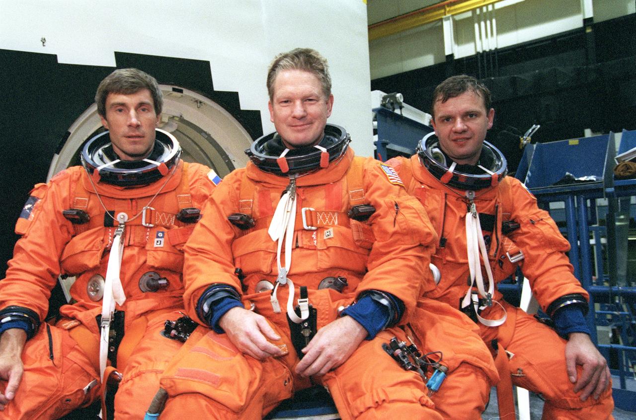 JSC2000-04067 (12 May 2000) --- The ISS Expedition One crew takes a break from training in the systems integration facility at the Johnson Space Center  for a crew photo.  From the left are  cosmonaut Sergei Krikalev, flight engineer; astronaut William Shepherd, mission commander; and cosmonaut Yuri Gidzenko, Soyuz commander.  The trio is sitting on the hatch for one of the full-scale mockups used to prepare the crew for certain phases and contingencies of their shuttle  return flight.