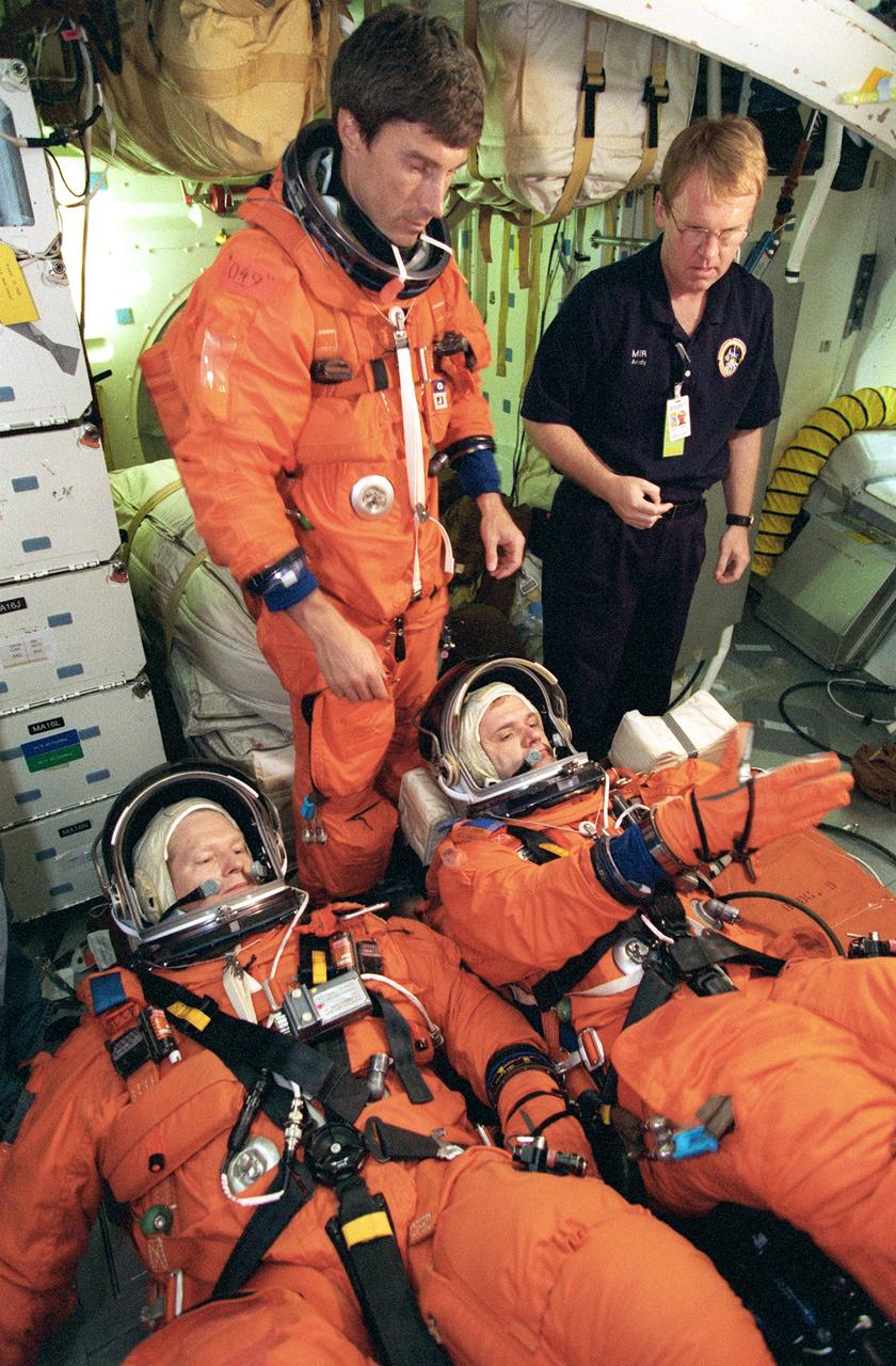 JSC2000-04073 (12 May 2000) --- Astronaut William Shepherd (bottom left), Expedition One mission commander, and cosmonaut Yuri Gidzenko, Soyuz commander,  lie on couches on the mid deck of a Johnson Space Center trainer during a rehearsal of shuttle descent. Cosmonaut Sergei Krikalev,  the third Expedition One crew member, is not yet positioned on his couch. He will serve as flight engineer for the crew. Next to him is astronaut Andrew S.W. Thomas, who assisted in the shuttle-descent simulation in one of the Johnson Space Center's Crew Compartment Trainers (CCT).