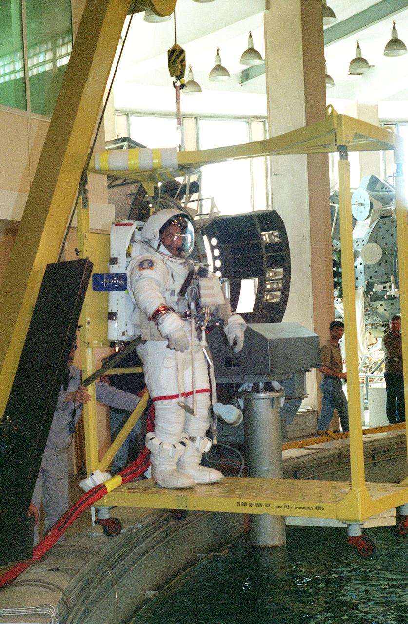 JSC2000-04864 (19 May 2000) --- Equipped with a shuttle extravehicular mobility unit (EMU) space suit, astronaut Edward T. Lu is about to lowered into the water prior to a spacewalk rehearsal in the Hydrolab facility at the Gagarin Cosmonaut Training Center in Star City, Russia. Lu, STS-106 mission specialist, was joined by astronaut Daniel C. Burbank (out of frame), for the simulation.