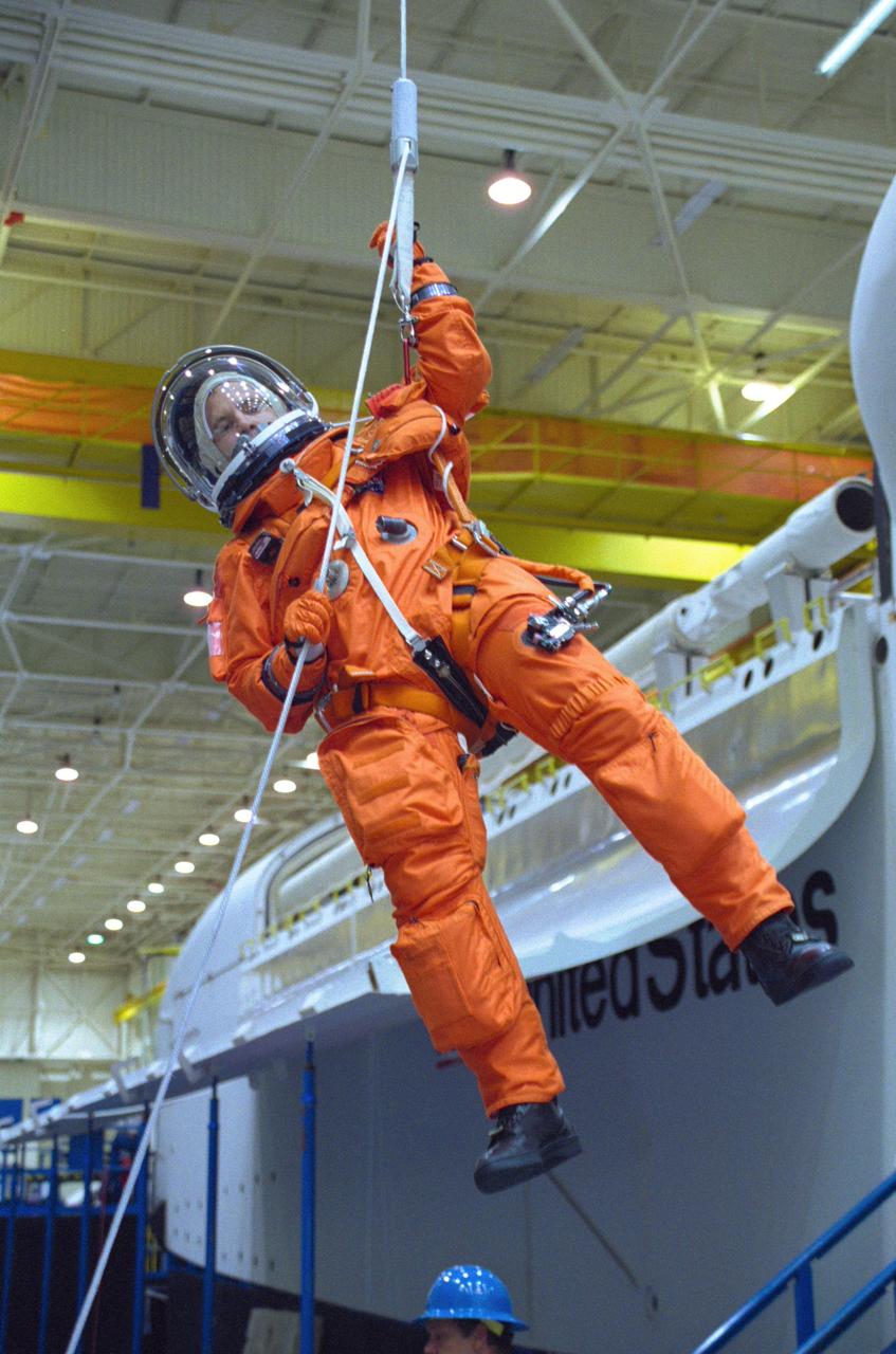 JSC2000-05554 (3 August 2000) --- Astronaut Paul W. Richards, STS-102 mission specialist, rappels from the top of the shuttle full fuselage trainer (FFT) during an emergency egress training exercise at the Johnson Space Center's Systems Integration Facility.