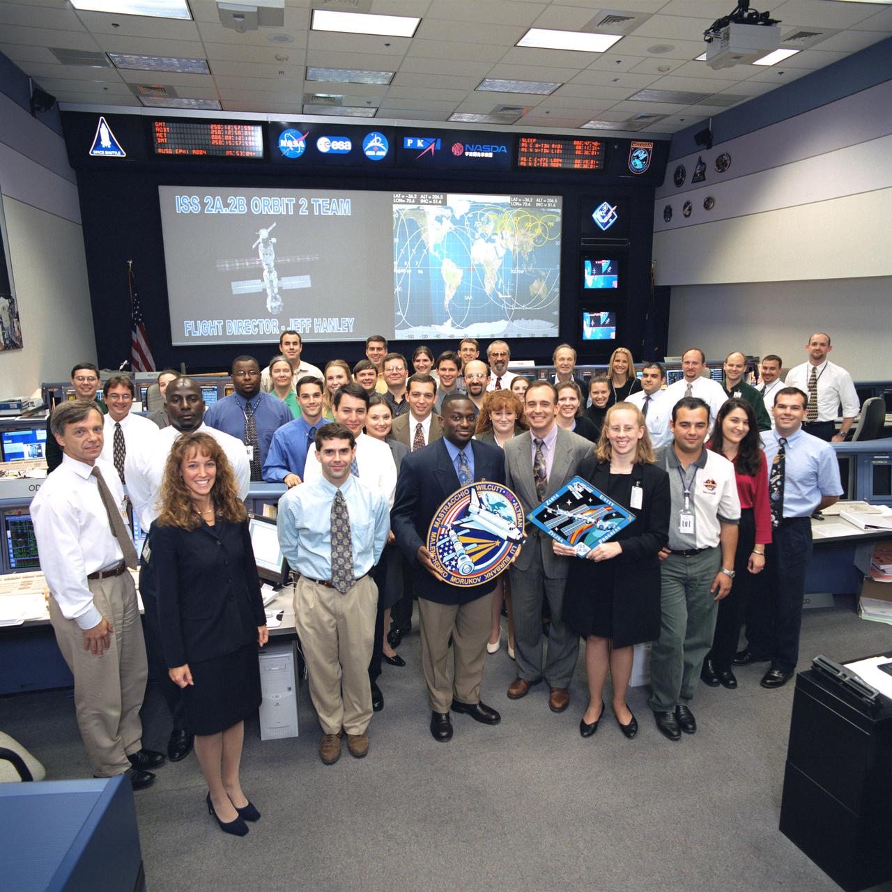 JSC2000-06244 (September 2000)--- Flight director Jeff Hanley, front center, and the fifty-odd flight controllers making up the ISS Orbit 2 Team pose for their group portrait in the ISS Flight Control Room of Houston's Mission Control Center.