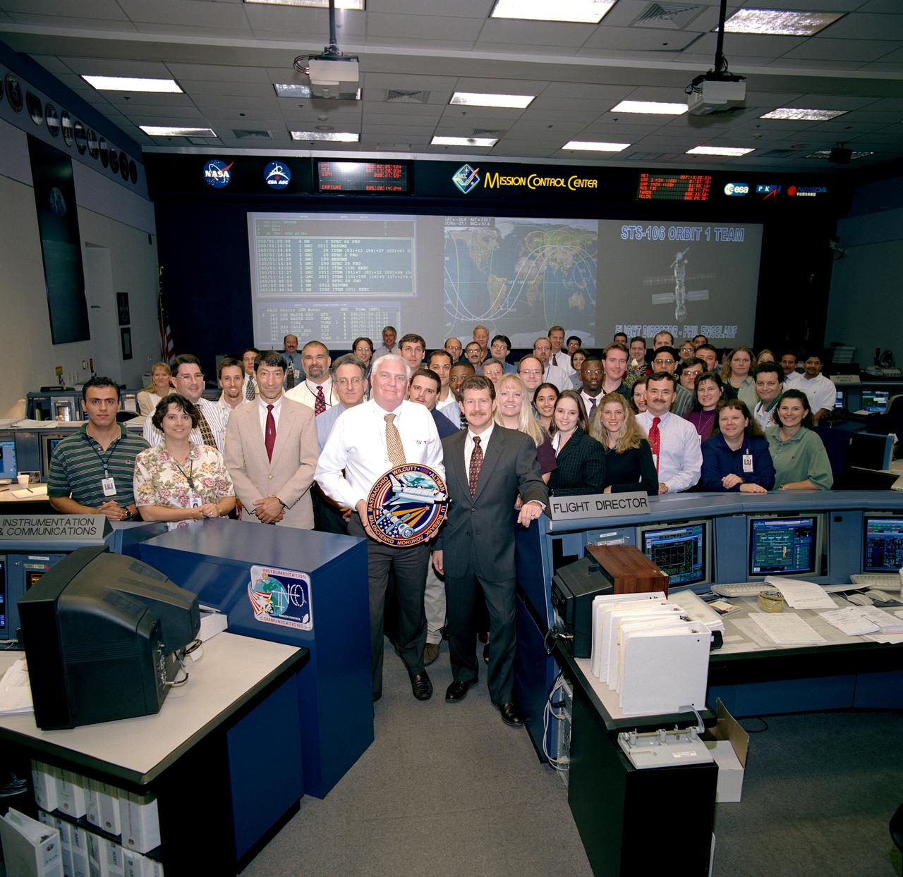 JSC2000-06253 (15 Sept. 2000) --- Flight director Phil Engelauf, front center, and the other fifty-odd flight controllers making up the STS-106 Orbit 1 team, pose for their group portrait in the Flight Control Room of Houston's Mission Control Center.