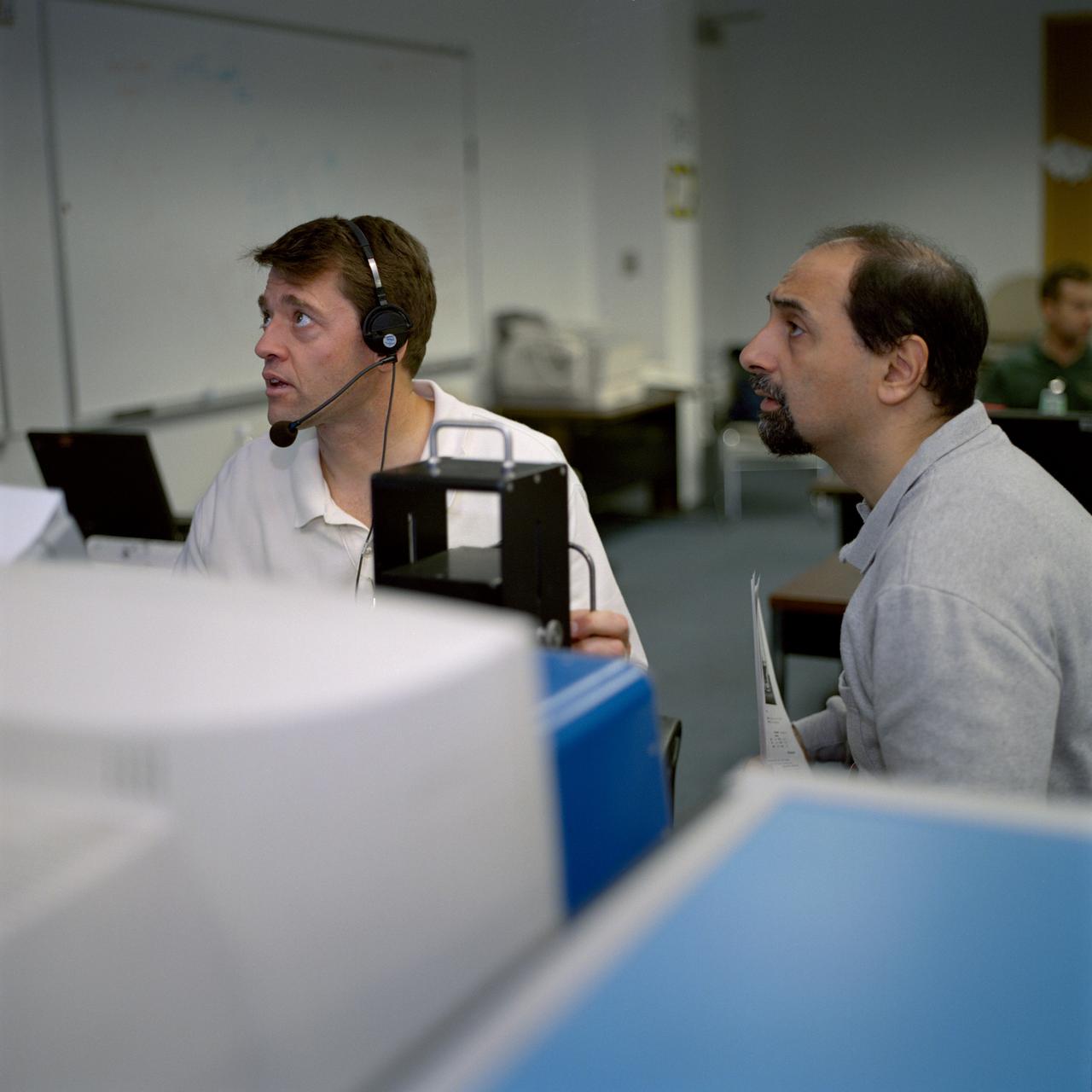 JSC2000-07405 (1 Dec. 2000) --- Astronauts Jeffrey S. Ashby (left), STS-100 pilot, and Umberto Guidoni, mission specialist representing the European Space Agency (ESA), use remote monitors to watch the spacewalk simulation by crewmates Scott E. Parazynski and Chris A. Hadfield at the Neutral Buoyancy Laboratory (NBL) near NASA's Johnson Space Center.