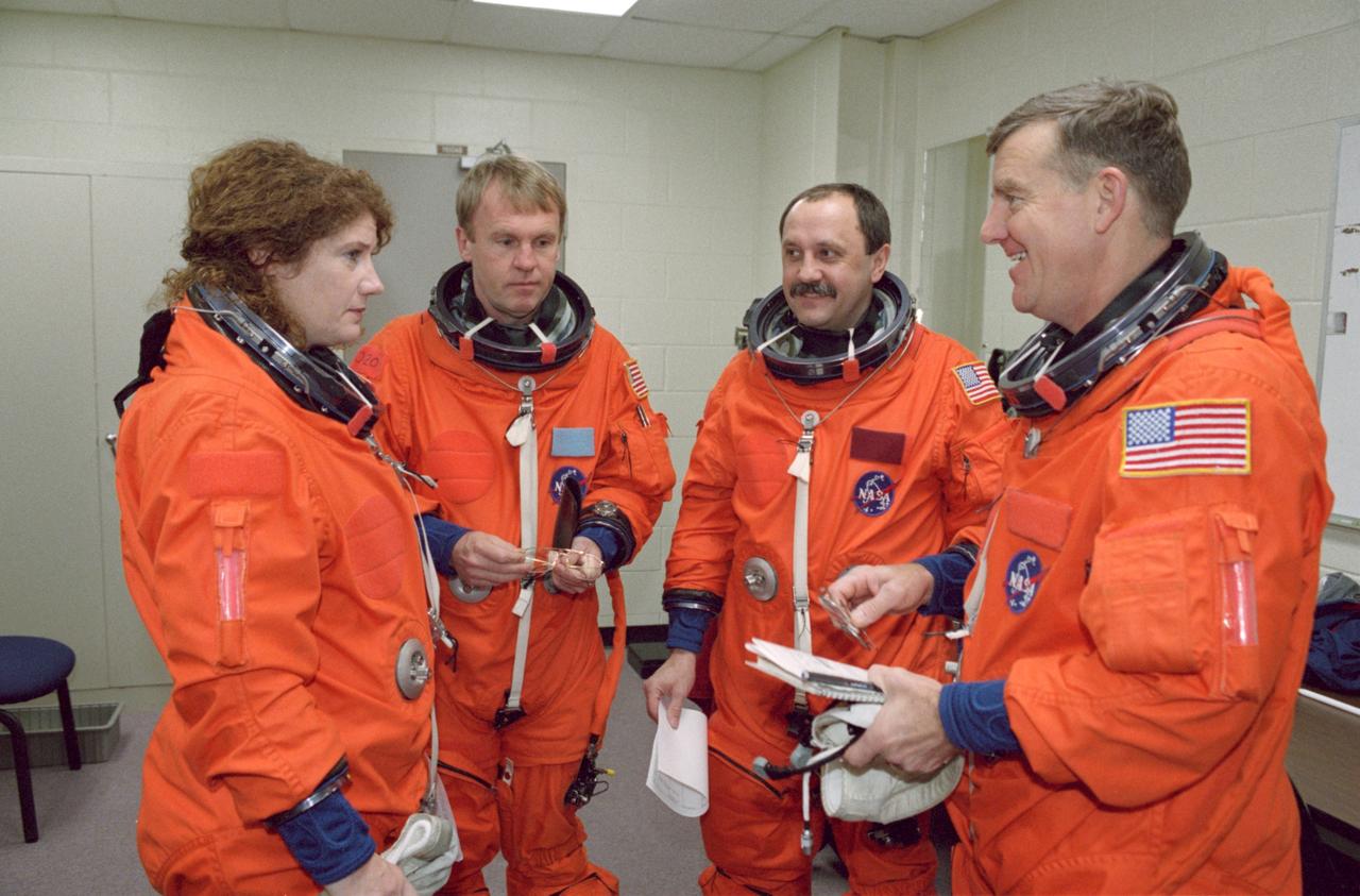 JSC2000-07449 (6 December 2000) --- Astronaut Andrew S.W. Thomas (second left), STS-102 mission specialist, chats with the Expedition Two crew members prior to a simulation exercise in the Systems Integration Facility at the Johnson Space Center. The station crew members are, from left, astronaut Susan J. Helms, cosmonaut Yury V. Usachev and astronaut James S. Voss.  Usachev is commander for the second station crew, which will replace the initial group onboard the outpost.  The three station crew members will accompany the STS-102 crew aboard the Space Shuttle Discovery to the outpost in March of next year.
