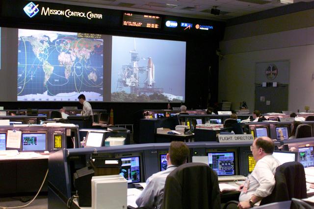 JSC2000-E-22286 (8 September 2000) --- An overall shot in Houston's Mission Control Center (MCC) shows flight controllers awaiting the launch of the Space Shuttle Atlantis from the Kennedy Space Center (KSC) in Florida.  The vehicle later launched on schedule, at 8:46 a.m. (EDT), September 8, 2000, as the Johnson Space Center (JSC) flight control team took the baton from KSC's launch controllers.  According to flight director Bill Reeves, "The picture referenced was taken less than an hour before launch for STS-106, before we changed the front screens for ascent operations. Wayne Hale (in glasses) is the Flight director for ascent and LeRoy Cain seated to his left was serving as "Weather Flight" for Wayne.   The console in the front right corner of the room next to the screens is the Ground Control position, where I was supporting at this time. The man with white hair is Norn Talbott, who will be retiring after this flight with more than 35 years at NASA. Ray Grossman is next to him, who is training to take his place on the GC Ascent Team. I am in fron of and slightly to the right of Ray. As you can see by the boxes at the consoel behind us (Mechanical), we come well prepared for all contingencies, including donuts for early morning shifts. We were on console by 2:00 am central time for the 7:45 am launch." Reference: https://spaceflight.nasa.gov/feedback/expert/answer/mcc/sts-106/09_14_09_35_19.html