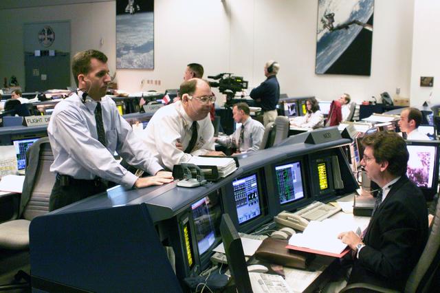 JSC2000-E-22288 (8 September2000) --- In Houston's Mission Control Center, flight directors LeRoy Cain, from left foreground, Wayne Hale and Jeffrey Bantle await the launch of the Space Shuttle Atlantis in Florida. The flight director console is on the left side of the frame.  Bantle is seated at the Missions Operations Directorate (MOD) console.  Once the shuttle clears the launch tower in Florida, the &quot;baton&quot; gets handed off to the flight controllers in Houston.