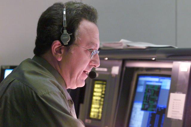 JSC2000-E-22723 (10 September 2000) --- Rob Navias, at the Public Affairs Officer (PAO) console in Houston's Mission Control Center, describes the docking of the Space Shuttle Atlantis and the International Space Station (ISS).