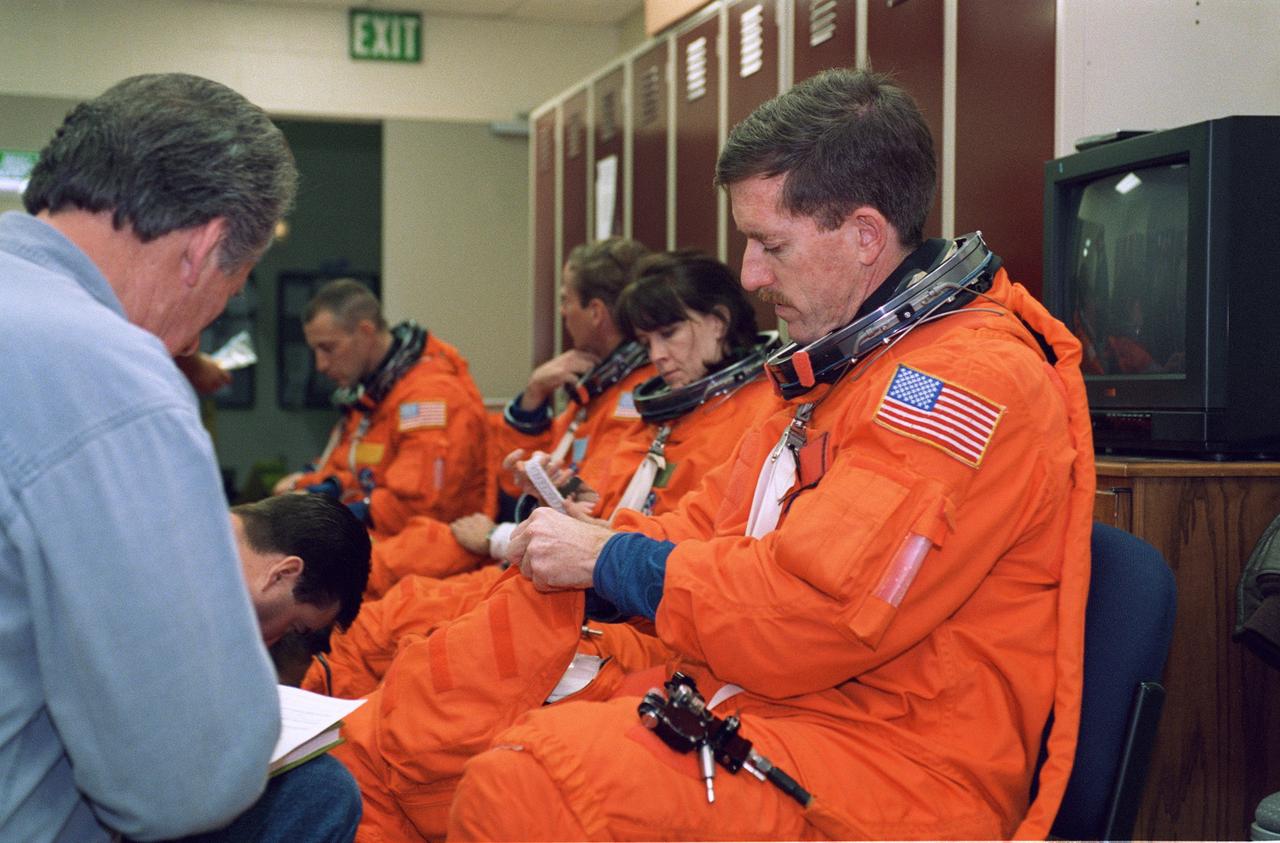 JSC2001-00083 (January 2001) --- Several members of the STS-104 crew, assisted by suit technician Jim Cheatham, don training versions of the full-pressure launch and entry suit prior to a training session in one of the trainer/mockups (out of frame) in the Johnson Space Center&#0146;s Systems Integration Facility.  Pictured (from right foreground) are astronauts James F. Reilly, Janet L. Kavandi, Michael L. Gernhardt, and Charles O. Hobaugh.