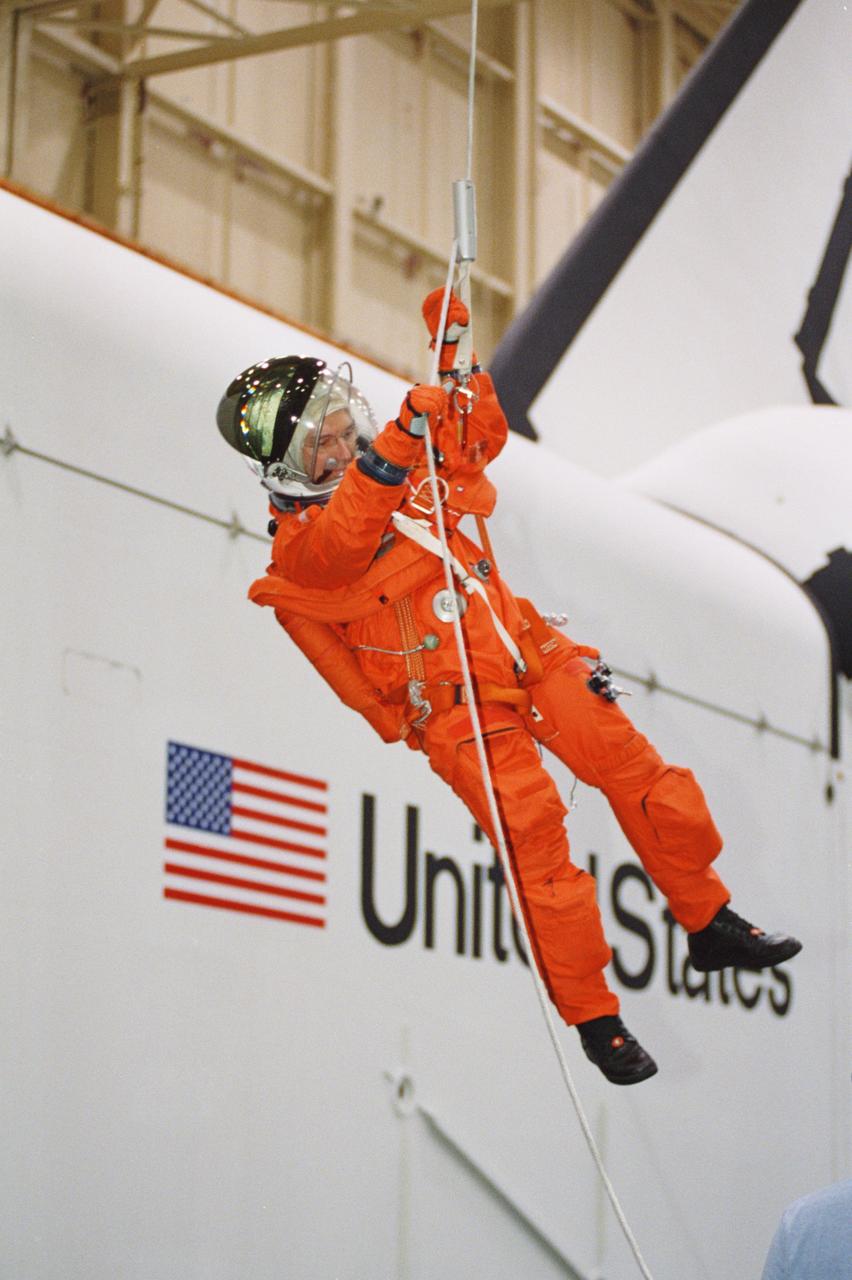JSC2001-01466 (18 May 2001) --- Astronaut Carl E. Walz, Expedition Four flight engineer, lowers himself from a simulated shuttle in trouble during an emergency egress training session in the Space Vehicle Mockup Facility at the Johnson Space Center (JSC).