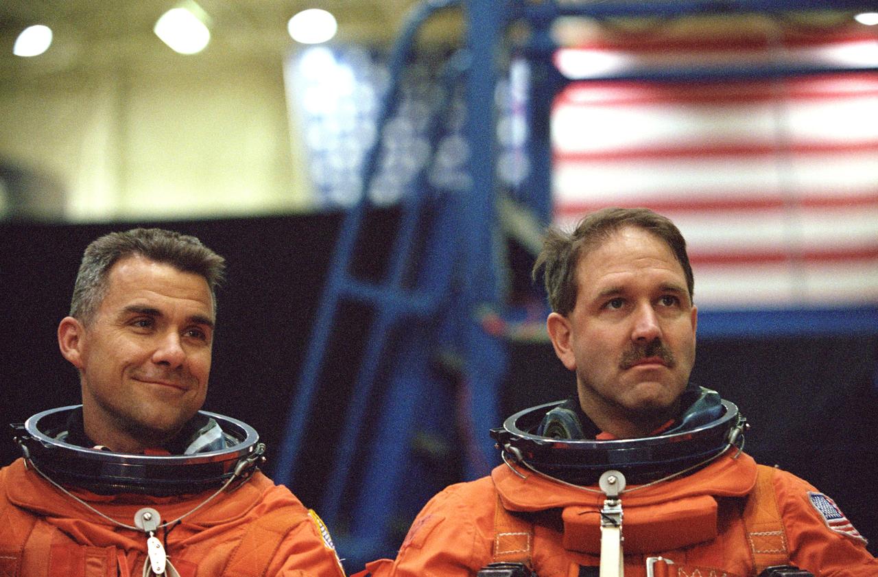JSC2001-01549 (24 May 2001) --- Suited in training versions of the full-pressure launch and entry suit, astronauts Duane G. Carey (left), STS-109 pilot, and John M. Grunsfeld, mission specialist, await the start of a training session in one of the trainer/mockups (out of frame) in the Space Vehicle Mockup Facility at the Johnson Space Center (JSC). STS-109 will be the 108th shuttle flight and the fourth Hubble Space Telescope (HST) servicing mission.