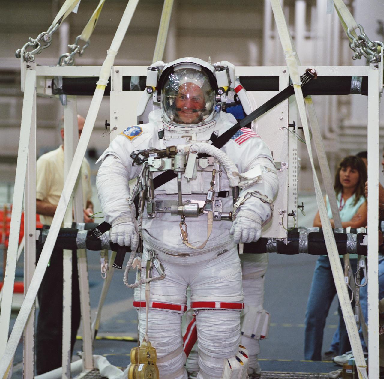 JSC2001-01607 (1 June 2001) --- Astronaut Frederick W. Sturckow, STS-105 pilot, is photographed along with astronaut Patrick G. Forrester (partially out of frame) as they prepare to be submerged in the waters of the Neutral Buoyancy Laboratory (NBL) at the Johnson Space Center (JSC). Sturckow and Forrester are wearing the training version of the Extravehicular Mobility Unit (EMU) space suit.