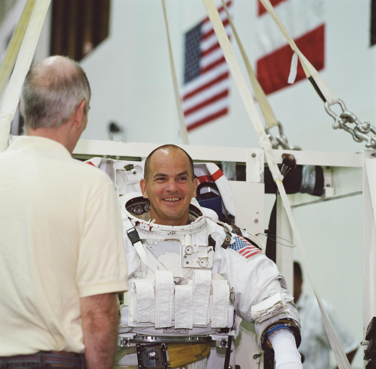 JSC2001-01610 (1 June 2001) --- Astronaut Frederick W. Sturckow, STS-105 pilot, is photographed as the final touches are made on the training version of his Extravehicular Mobility Unit (EMU) space suit prior to being submerged in the waters of the Neutral Buoyancy Laboratory (NBL) at the Johnson Space Center (JSC). Sturckow is assisted by fellow crewmember Daniel T. Barry, mission specialist.