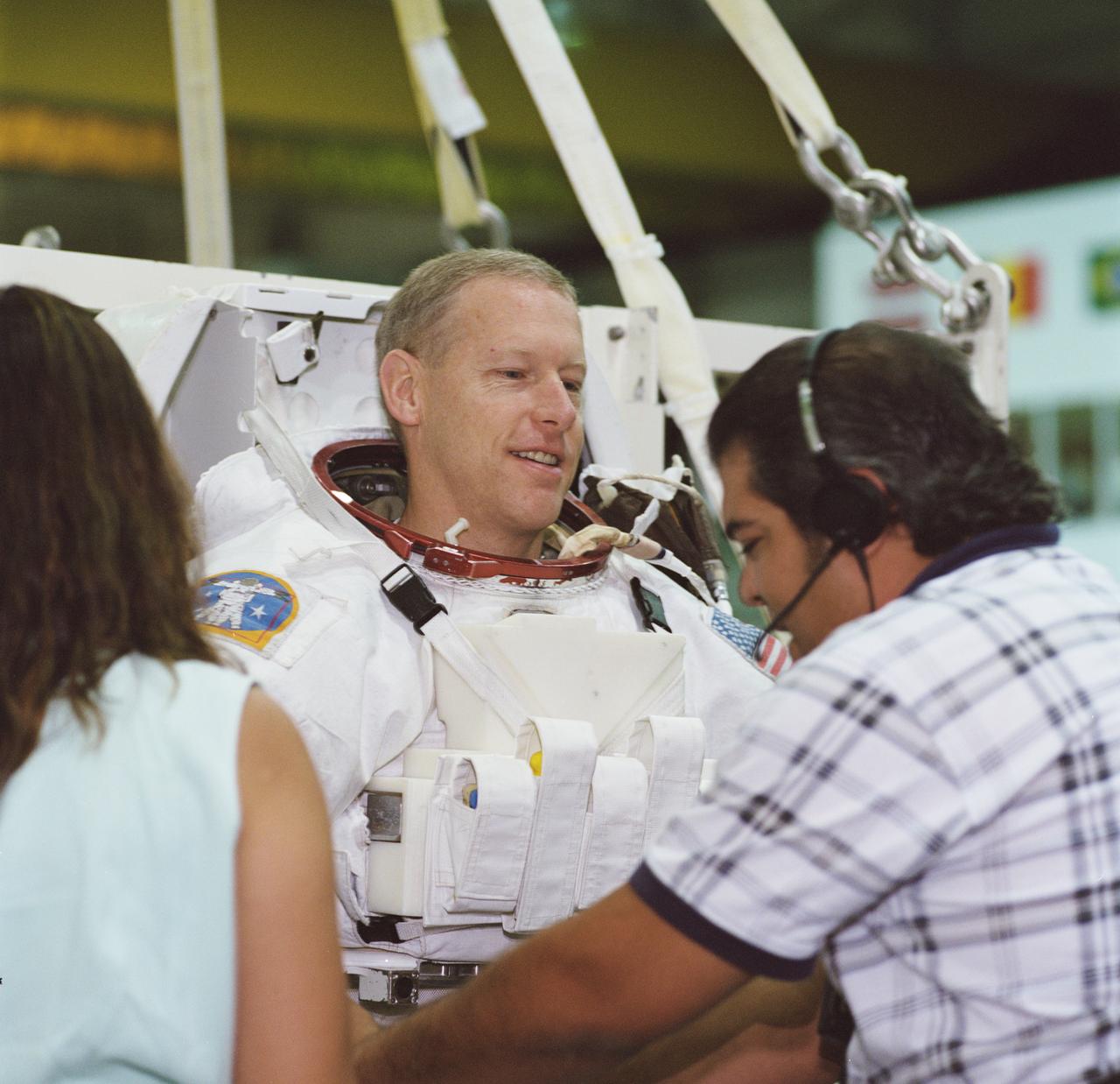 JSC2001-01611 (1 June 2001) --- Astronaut Patrick G. Forrester, STS-105 mission specialist, prepares to be submerged in the waters of the Neutral Buoyancy Laboratory (NBL) at the Johnson Space Center (JSC). Suit technician Joey Cambiaso assists Forrester with the training version of his Extravehicular Mobility Unit (EMU) space suit.