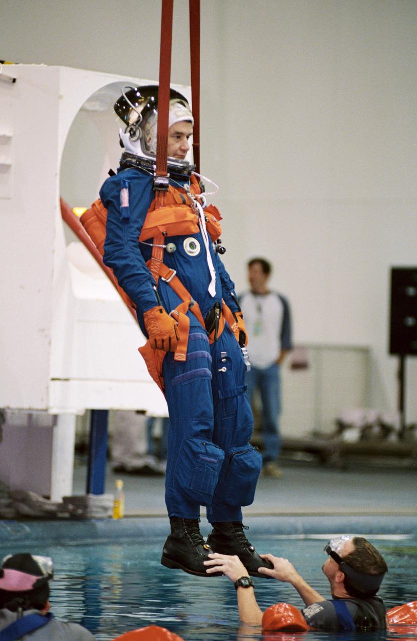 JSC2001-01922 (12 July 2001) --- Cosmonaut Valeri G. Korzun, Expedition Five mission commander, assisted by Johnson Engineering diver Gabriel Meyer, simulates a parachute drop into water during an emergency bailout training session in the Neutral Buoyancy Laboratory (NBL) near the Johnson Space Center (JSC). Korzun represents Rosaviakosmos.