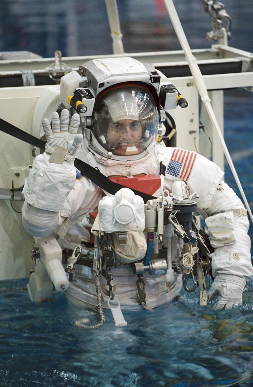 JSC2001-02939 (26 November 2001) --- Astronaut Philippe Perrin, STS-111 mission specialist, attired in a training version of the Extravehicular Mobility Unit (EMU) space suit, waves as he is submerged in the waters of the Neutral Buoyancy Laboratory (NBL) near the Johnson Space Center (JSC). Perrin represents CNES, the French Space Agency. STS-111 will be the 14th shuttle mission to visit the International Space Station (ISS).