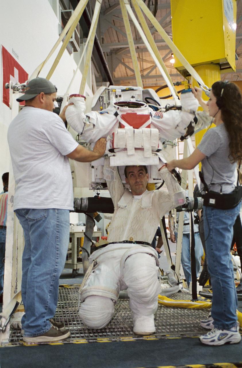JSC2001-02941 (26 November 2001) --- Astronaut Philippe Perrin, STS-111 mission specialist, dons a training version of the Extravehicular Mobility Unit (EMU) space suit prior to being submerged in the waters of the Neutral Buoyancy Laboratory (NBL) near the Johnson Space Center (JSC). Perrin, representing CNES, the French Space Agency, is assisted by crew trainers Don Post, Jr., and Nichole Starke. STS-111 will be the 14th shuttle mission to visit the International Space Station (ISS).