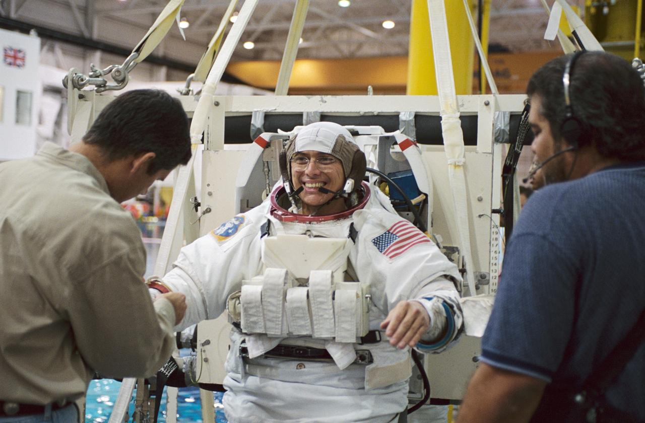 JSC2001-02945 (26 November 2001) --- Astronaut Franklin R. Chang-Diaz, STS-111 mission specialist, is photographed as the final touches are made on the training version of the Extravehicular Mobility Unit (EMU) space suit prior to being submerged in the waters of the Neutral Buoyancy Laboratory (NBL) near the Johnson Space Center (JSC). Fellow crewmember Paul S. Lockhart (left), pilot, and crew trainer Joe Cambiaso assist Chang-Diaz. STS-111 will be the 14th shuttle mission to visit the International Space Station (ISS).