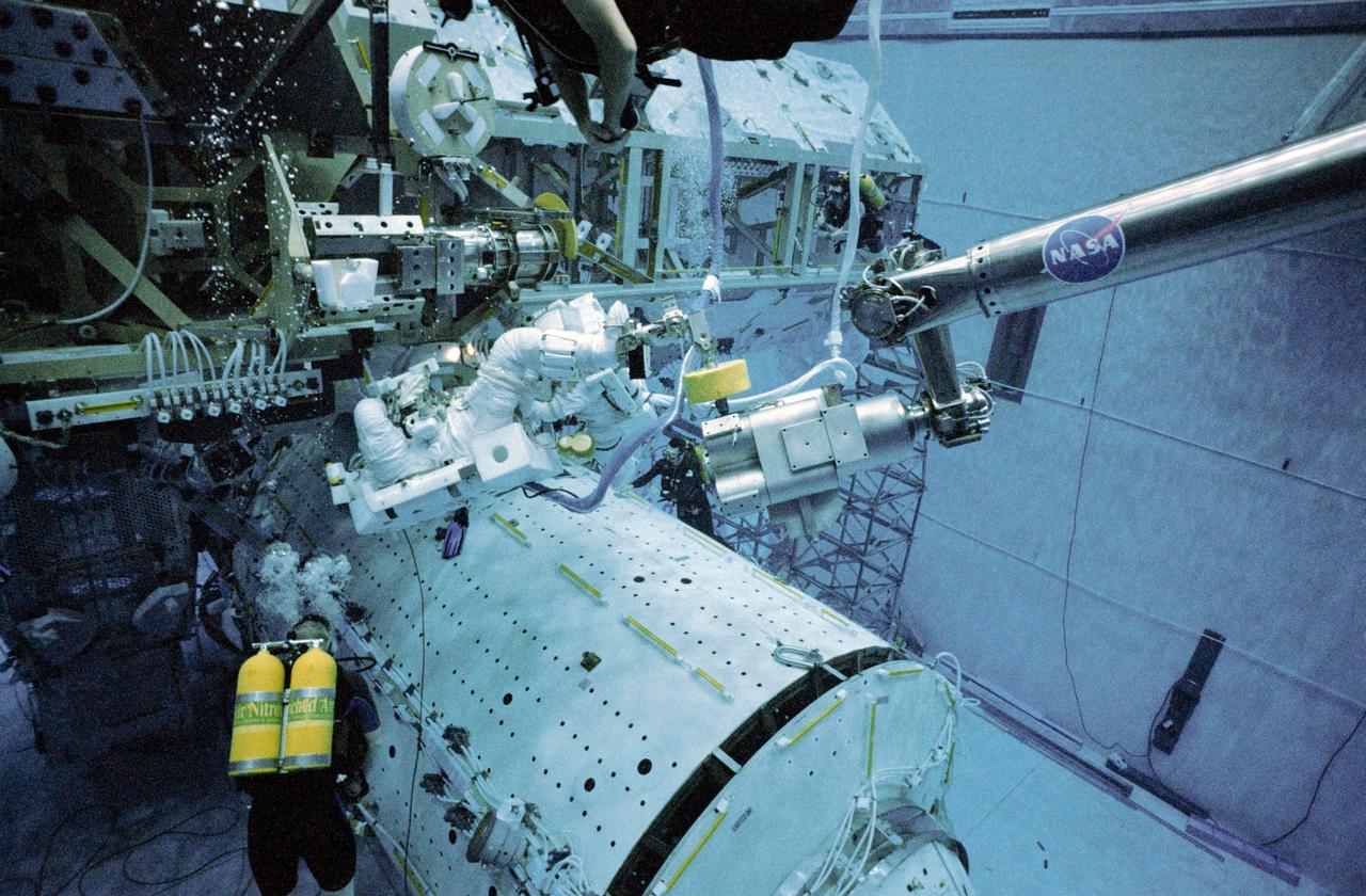 JSC2001-02995 (December 2001) --- Astronauts Philippe Perrin and Franklin R. Chang-Diaz practice procedures to be used during space walks scheduled to perform work on the International Space Station (ISS). The two STS-111 mission specialists, wearing training versions of the Extravehicular Mobility Unit (EMU) space suit, make use of the Neutral Buoyancy Laboratory (NBL) giant pool to rehearse their assigned chores. While the Space Shuttle Endeavour is docked to the orbital outpost, two space walks are scheduled to hook up the mobile base system, the second part of the mobile platform for the station’s Canadarm2 robotic arm and other assembly tasks. Perrin represents CNES, the French Space Agency. STS-111 will be the 14th shuttle mission to visit the orbital outpost.