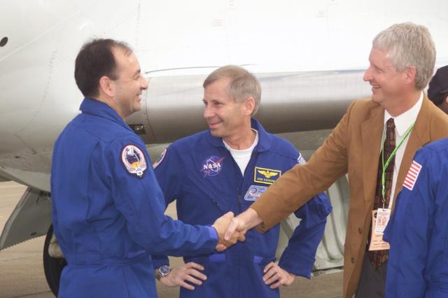 JSC2001-E-04804 (21 February 2001) --- Astronauts Mark L. Polansky (left) and Kenneth D. Cockrell (center), pilot and commander, respectively, for the STS-98 mission, are greeted by Steven A. Hawley of the Flight Crew Operations Directorate upon their return to Houston. The greetings took place prior to a welcoming ceremony at Ellington Field.