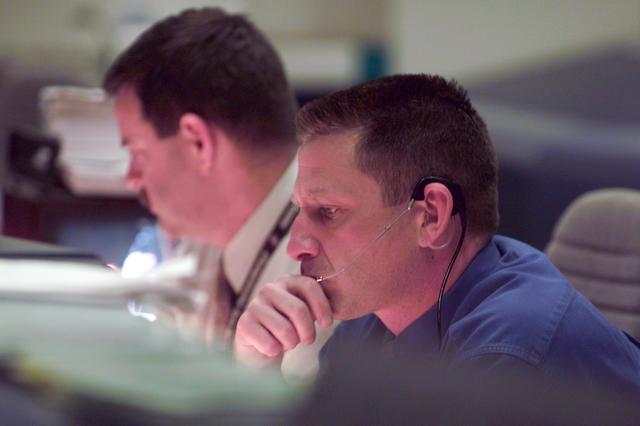 JSC2001-E-06204 (8 March 2001) --- At the Spacecraft Communicator (CAPCOM) console in Houston's Mission Control Center, astronauts Christopher J. (Gus) Loria (foreground) and Scott D. Altman monitor Discovery's pre-launch activity several hundred miles away in Florida.