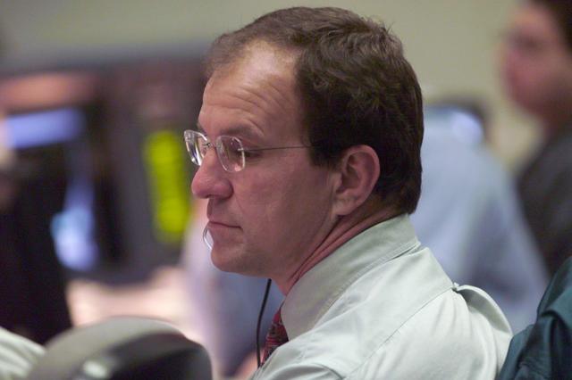 JSC2001-E-06212 (8 March 2001) --- Astronaut Michael J. Bloomfield at the Spacecraft Communicator (CAPCOM) console in JSC's Mission Control Center checks into possible weather effects for the scheduled launch of the Space Shuttle Discovery. Bloomfield was backing up weather CAPCOM Scott D. Altman, who was seated at the console, along with CAPCOM Christopher J. (Gus) Loria.