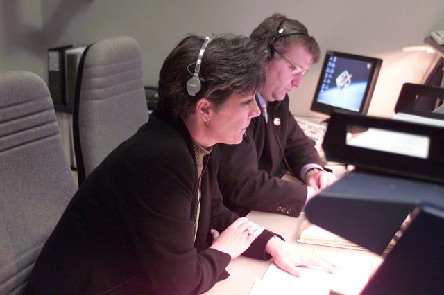 JSC2001-E-06218 (8 March 2001) --- Eileen Hawley and Daniel K. Carpenter look over launch data at the Public Affairs Officer (PAO) console in Houston's Mission Control Center (MCC). Hawley is the ascent commentator for PAO and Carpenter is JSC Director of Public Affairs.