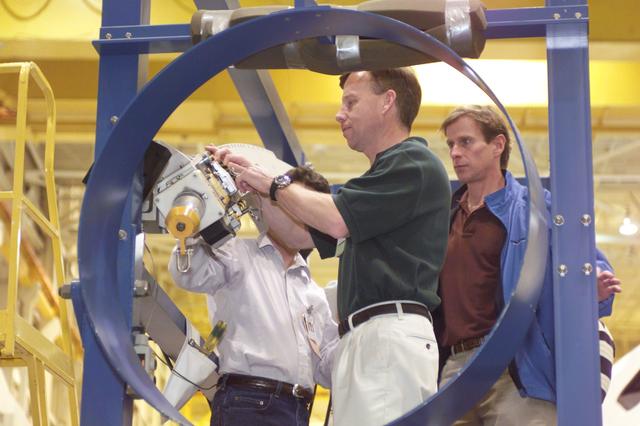 JSC2001-E-06397 (27 February 2001) --- Astronauts Steven W. Lindsey (center foreground), mission commander, and Michael L. Gernhardt (right), mission specialist, assisted by crew trainer Ken Trujillo, rehearse emergency egress procedures in the Systems Integration Facility at the Johnson Space Center (JSC). The crew will use the pictured training version of the launch escape pole which is now carried onboard for all shuttle flights. The STS-104 mission to the International Space Station (ISS) represents the Space Shuttle Atlantis' first flight using a new engine and is targeted for a liftoff no earlier than June 14, 2001.