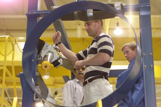 JSC2001-E-06399 (27 February 2001) --- Astronauts Charles O. Hobaugh (center foreground), pilot, and Michael L. Gernhardt (right), mission specialist, assisted by crew trainer Ken Trujillo, rehearse emergency egress procedures in the Systems Integration Facility at the Johnson Space Center (JSC). The crew will use a training version of the launch escape pole which is now carried onboard for all shuttle flights. The STS-104 mission to the International Space Station (ISS) represents the Space Shuttle Atlantis' first flight using a new engine and is targeted for a liftoff no earlier than June 14, 2001.