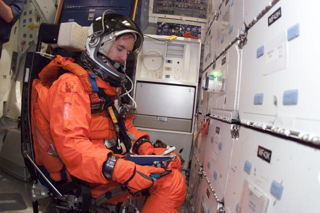 JSC2001-E-06426 (27 February 2001) --- Astronaut James F. Reilly, mission specialist, makes a notation during mission training in one of the high fidelity trainers/mockups in the Systems Integration Facility at Johnson Space Center (JSC). The STS-104 mission to the International Space Station (ISS) represents the Space Shuttle Atlantis' first flight using a new engine and is targeted for a liftoff no earlier than June 14, 2001.