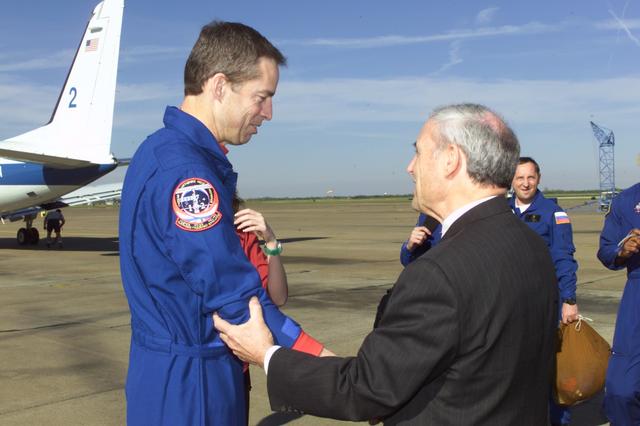 JSC2001-E-08304 (22 March 2001) --- Astronaut James D. Wetherbee (left), STS-102 mission commander, is greeted by JSC Acting Director Roy S. Estess following crew arrival at Ellington Field.