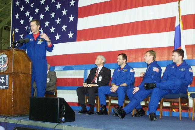 JSC2001-E-08322 (22 March 2001) --- Astronaut James D. Wetherbee, STS-102 mission commander, speaks to a crowd of greeters during a crew return ceremony in Ellington Field's Hangar 990.  Pictured in the background on the dais are (from the left) Roy S. Estess, Johnson Space Center's Acting Director;  along with astronauts Paul W. Richards,  Andrew S.W. Thomas and James M. Kelly  of the STS-102 crew.